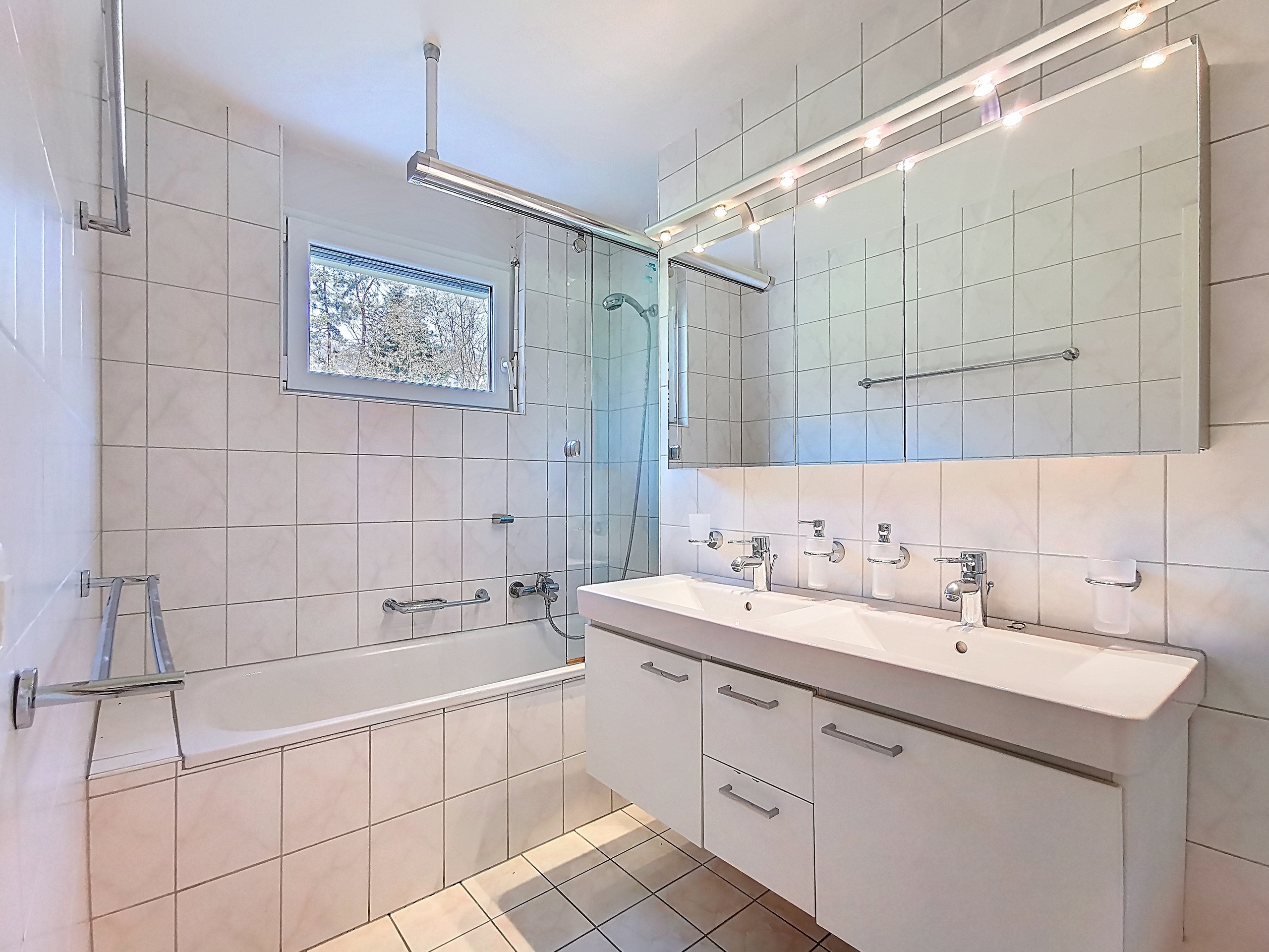Helles Badezimmer mit Doppelwaschtisch und Badewanne