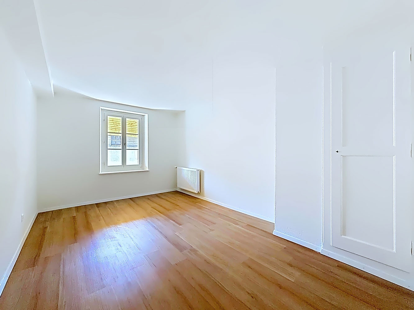 Heller leerer Raum mit Parkett und Fenster
