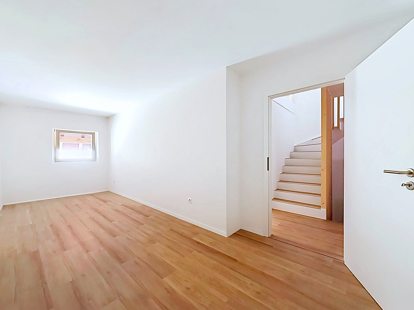 Heller leerer Raum mit Holztreppe