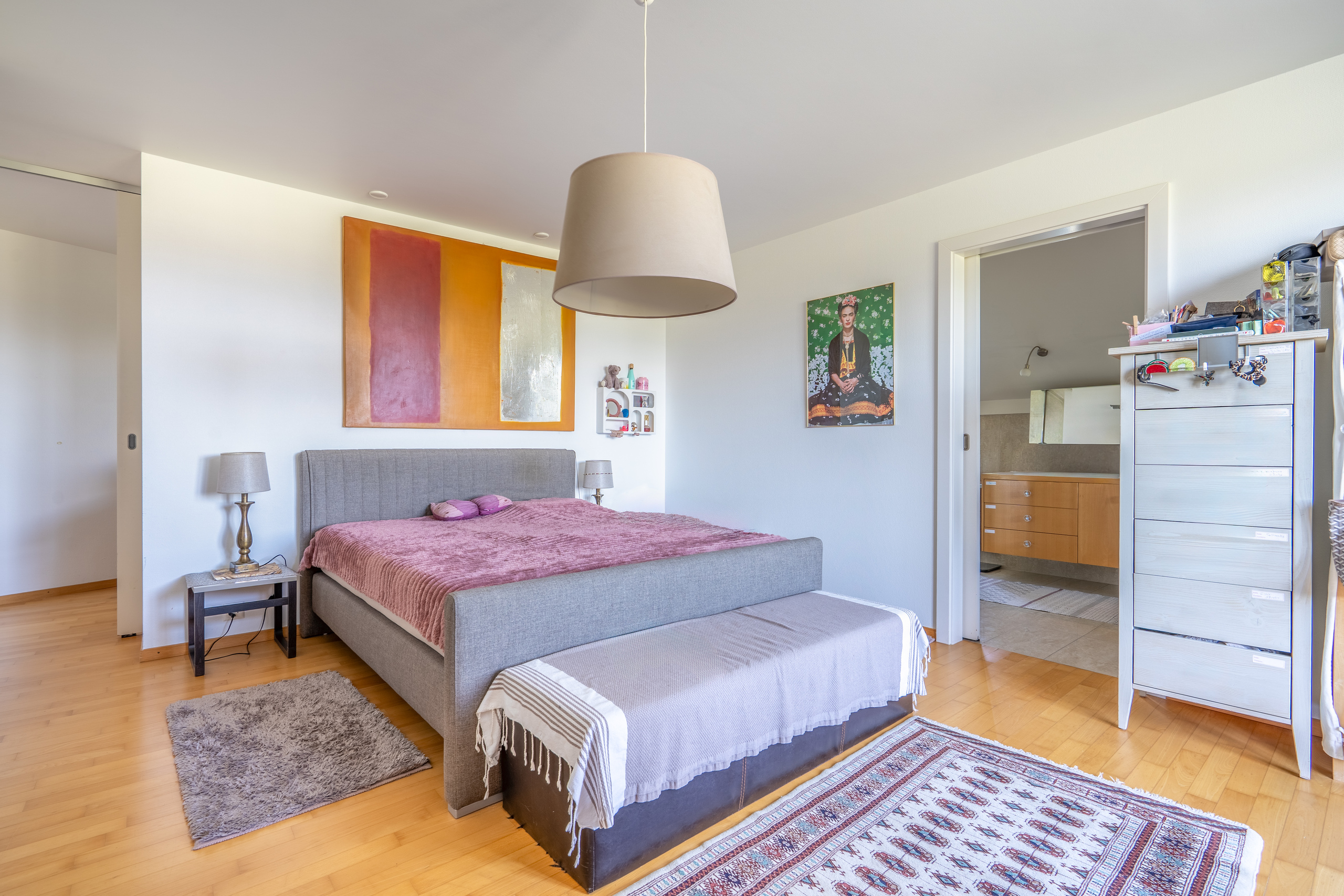 Helles Schlafzimmer mit großem Bett und Holzboden