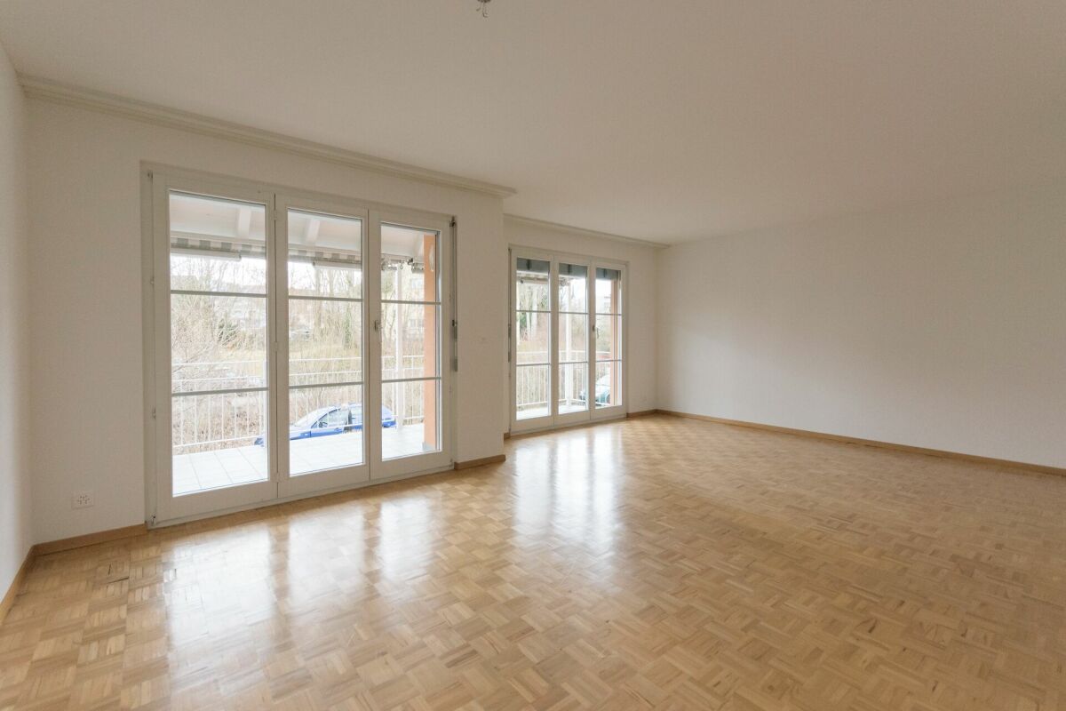 Heller leerer Wohnraum mit großen Fenstern