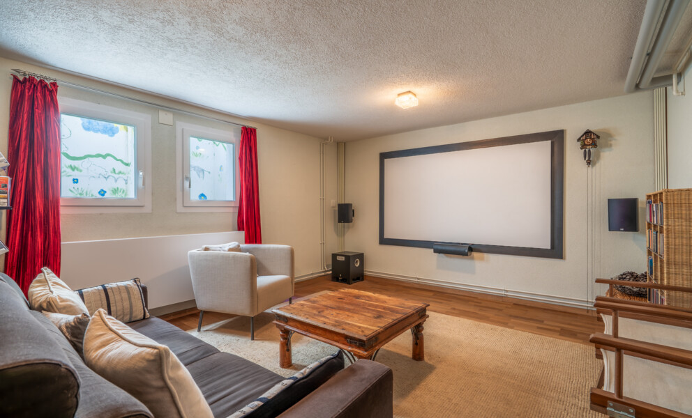 Heimkino-Wohnraum mit Sofa und Projektionsleinwand