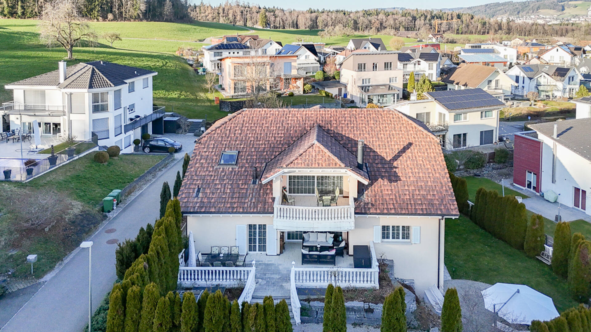 Villa mit großem Satteldach und Dachterrassen in Wohnsiedlung