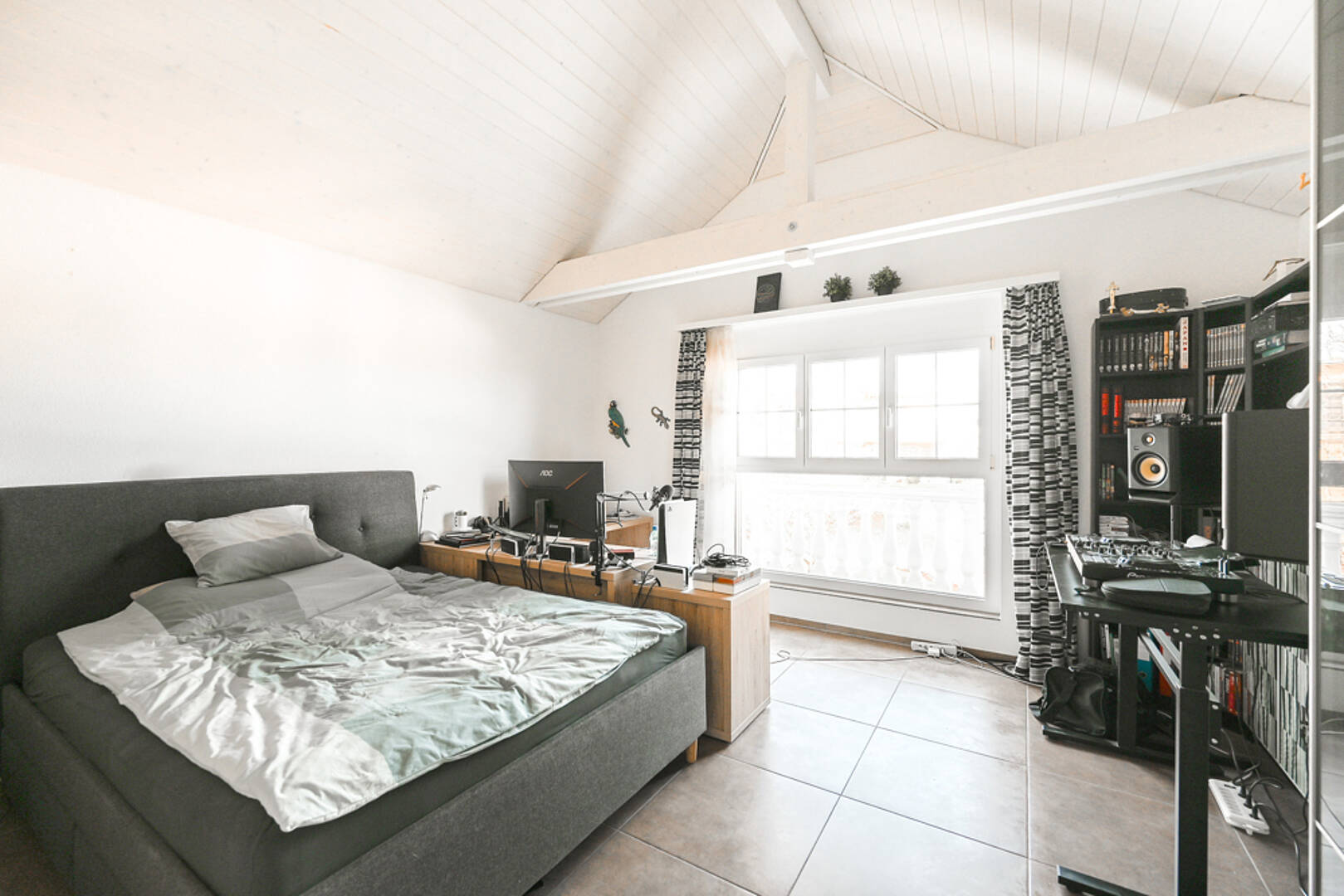 Helles Schlafzimmer mit Arbeitsbereich im Dachgeschoss