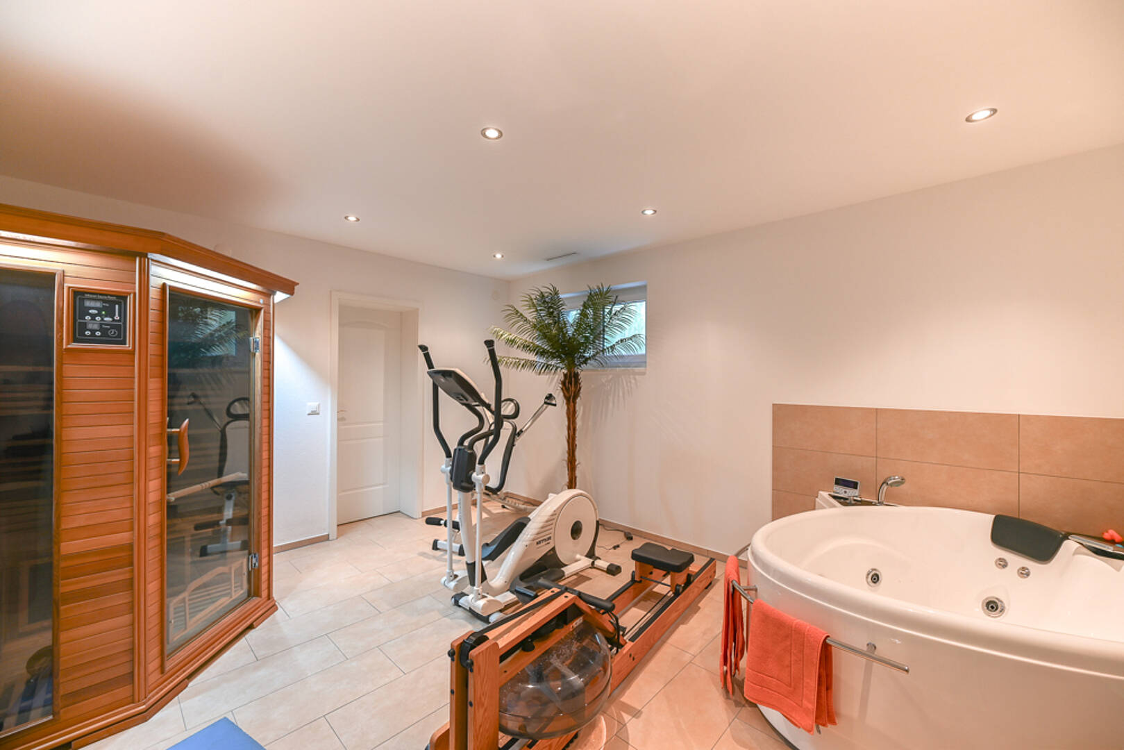 Heller Wellnessraum mit Fitness- und Spa-Ausstattung