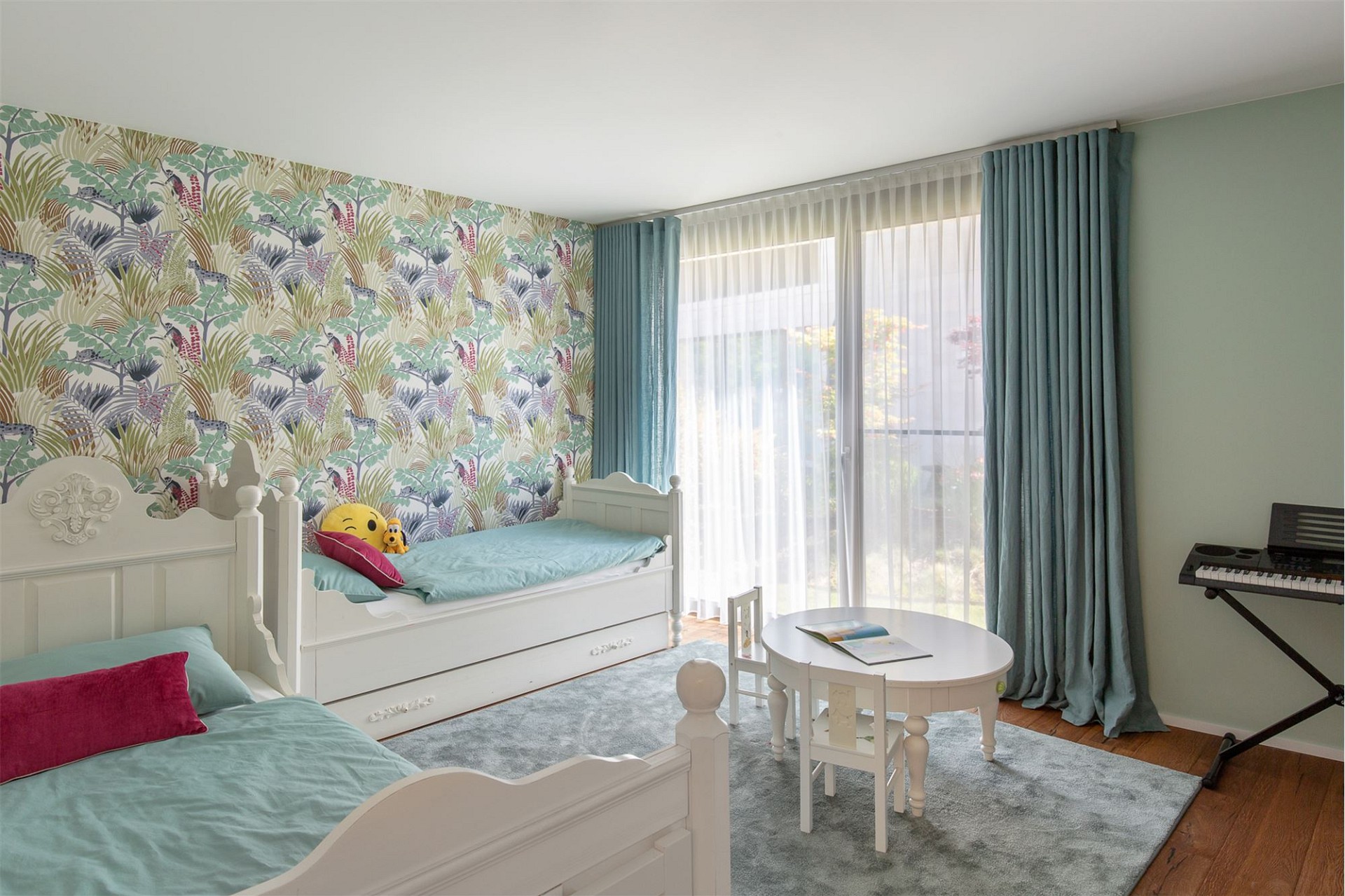 Kinderzimmer mit zwei Betten und verspielter Tapete
