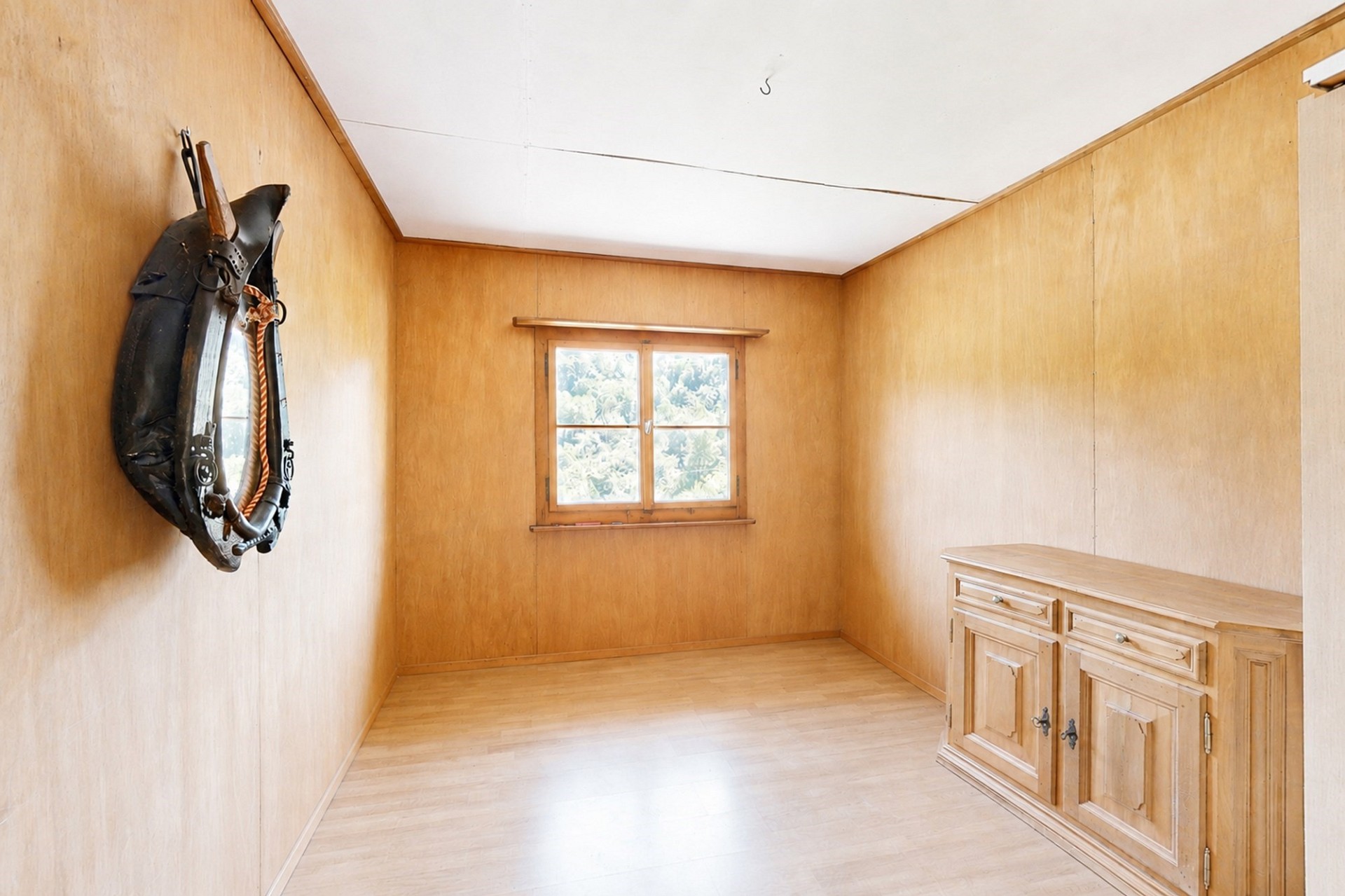 Leerer Holzraum mit Fenster und Sideboard