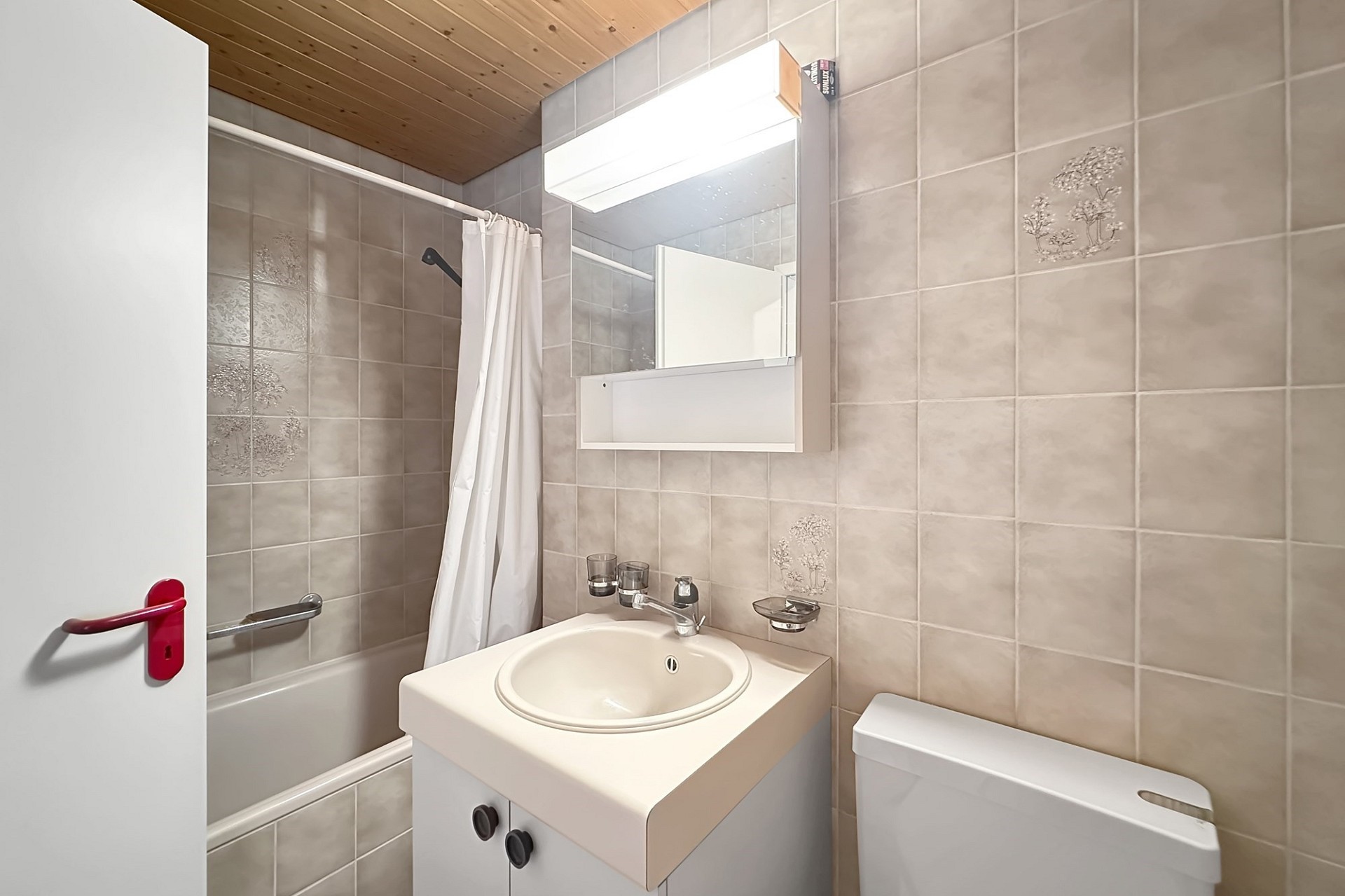 Kleines Badezimmer mit Badewanne und Spiegel