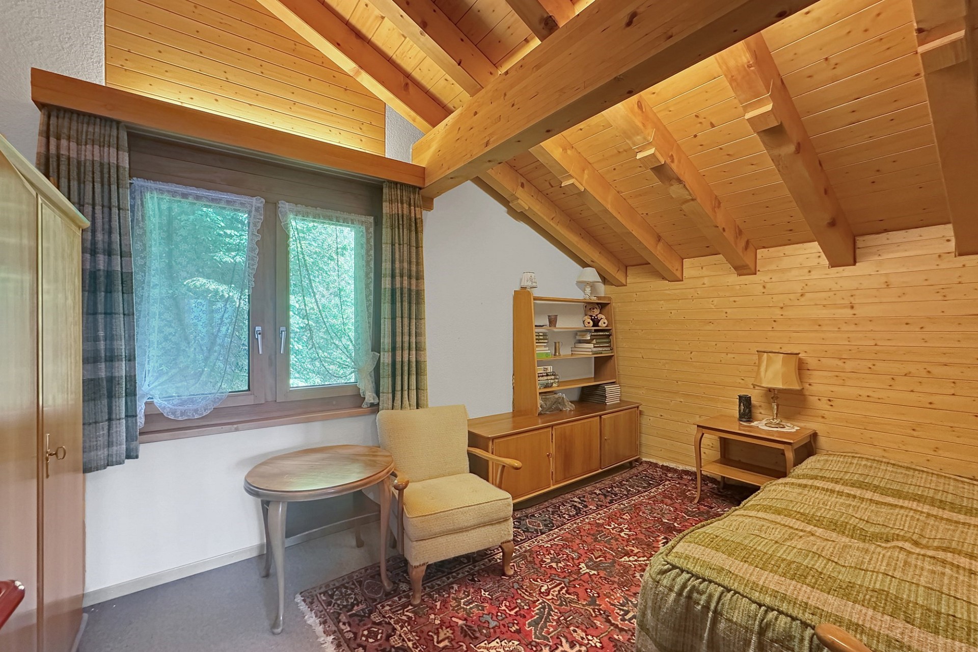 Gemütliches Schlafzimmer im Dachgeschoss mit Holzverkleidung