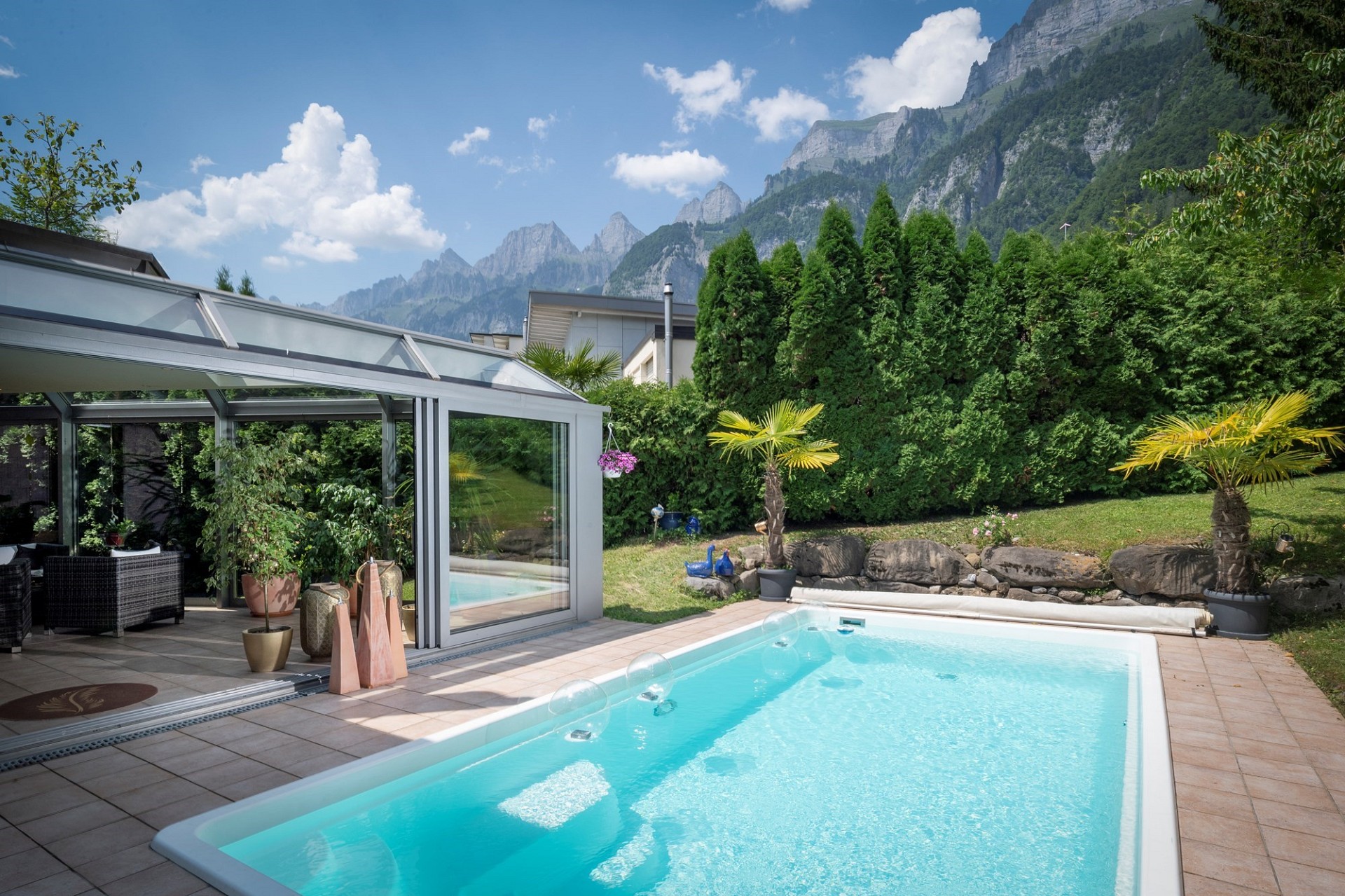 Poolbereich mit Wintergarten und Bergblick