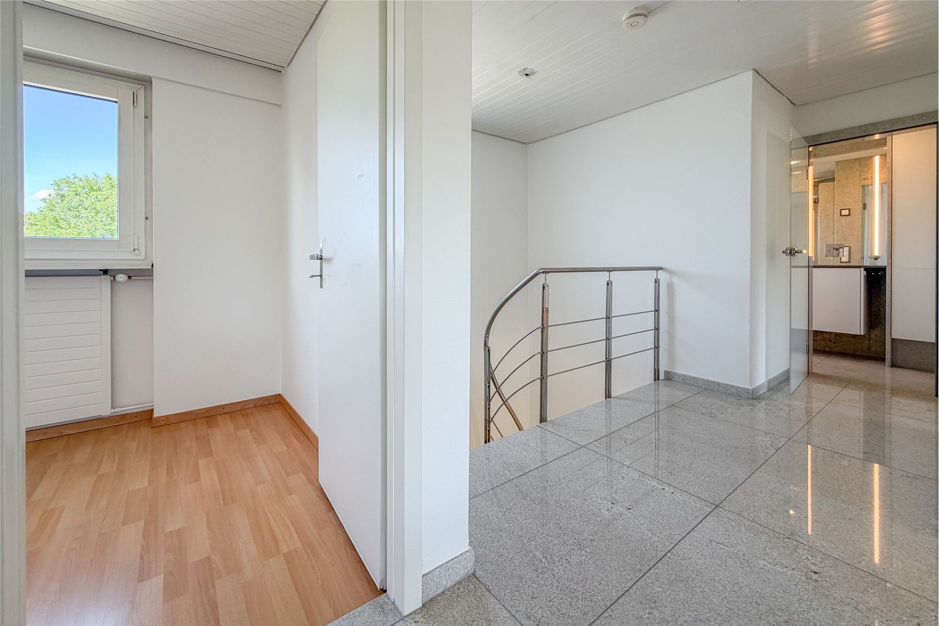 Heller Flur mit Treppe und zwei Bodenbelägen
