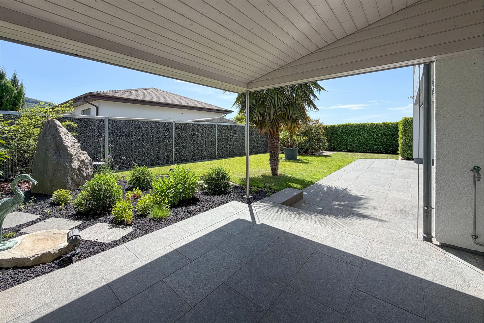 Überdachte Terrasse mit Gartenblick