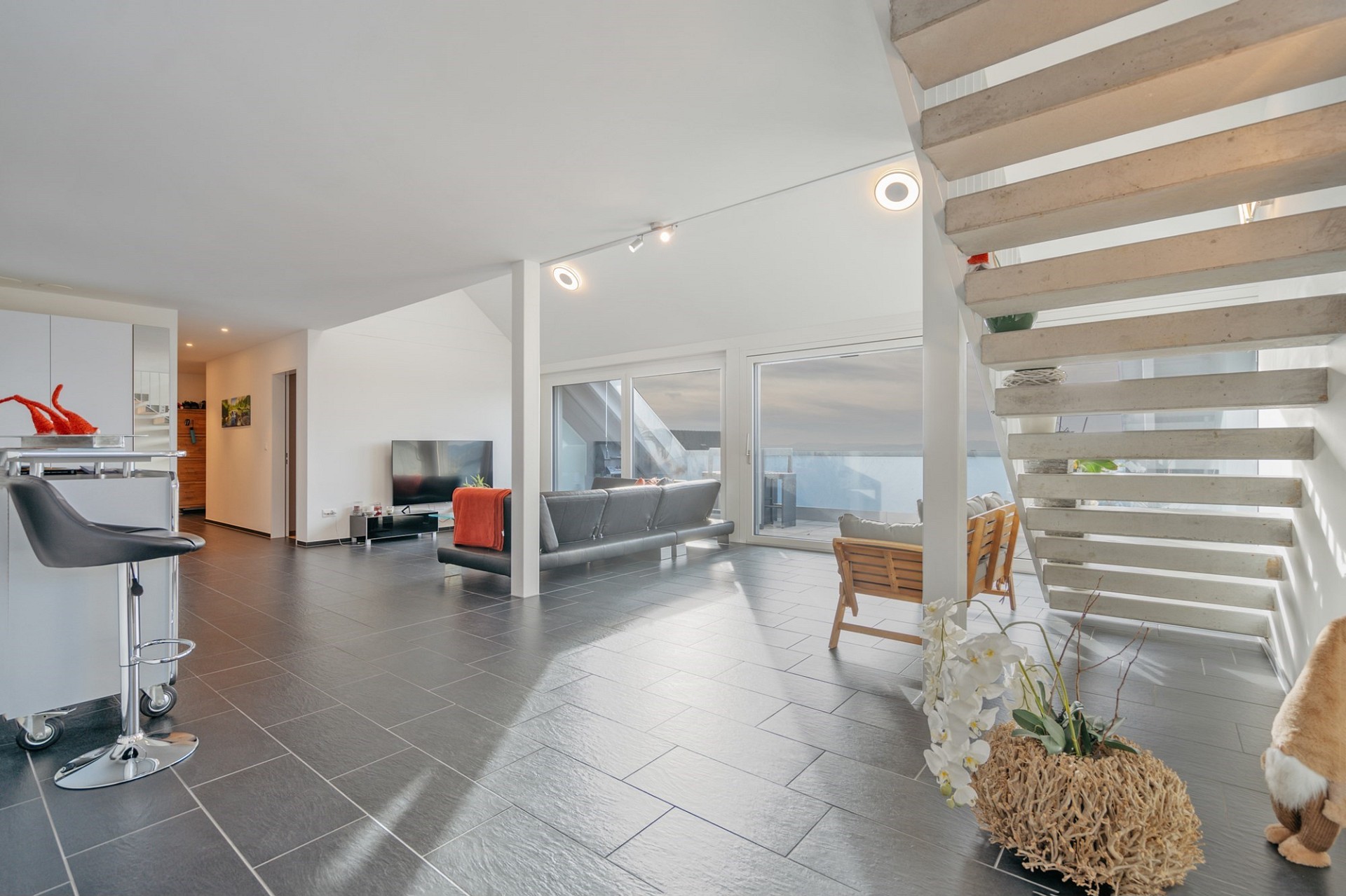 Offener Wohnbereich mit Treppe und Terrasse