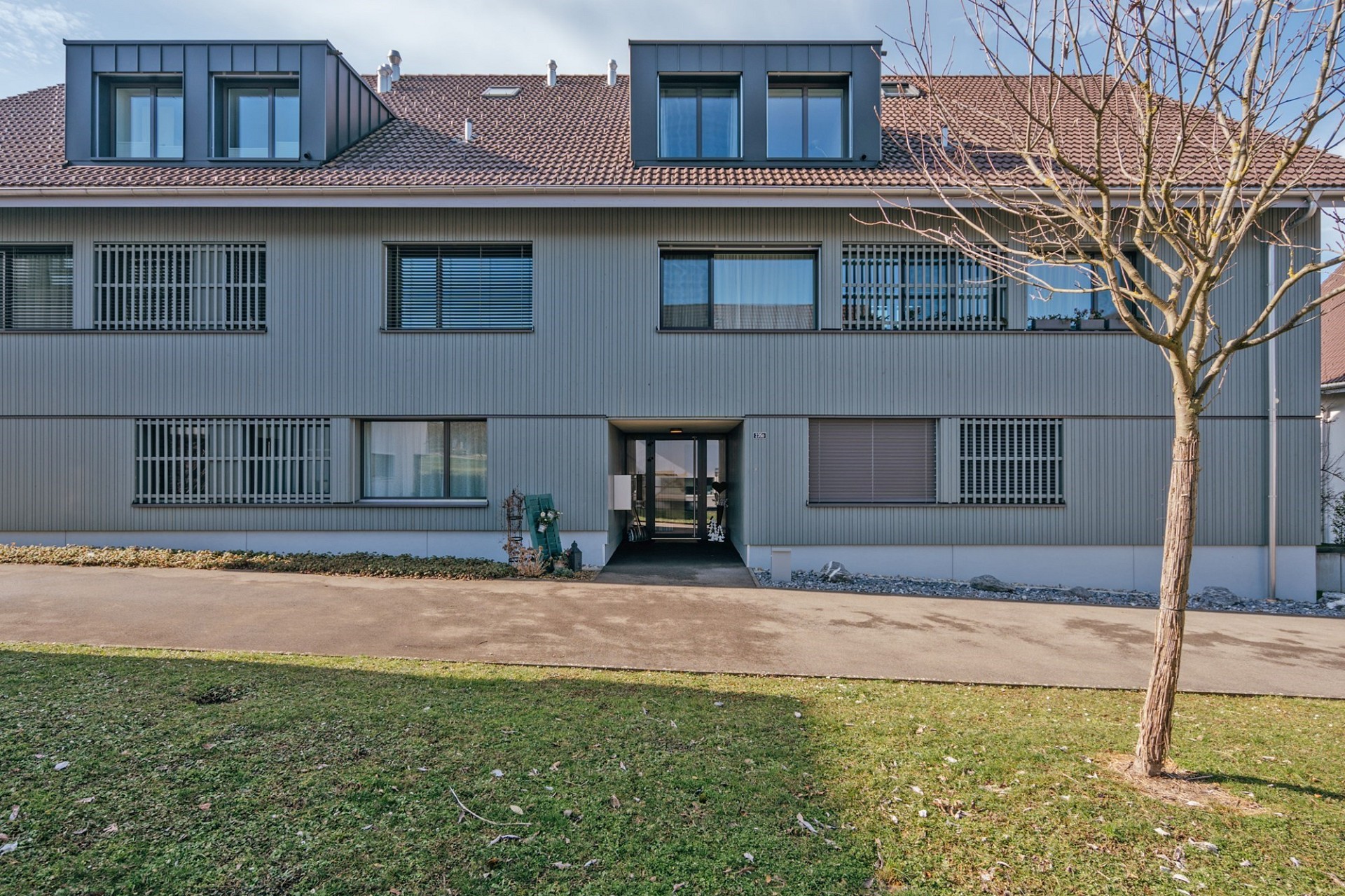 Mehrfamilienhaus mit Mansarddach und verglaster Eingangszone