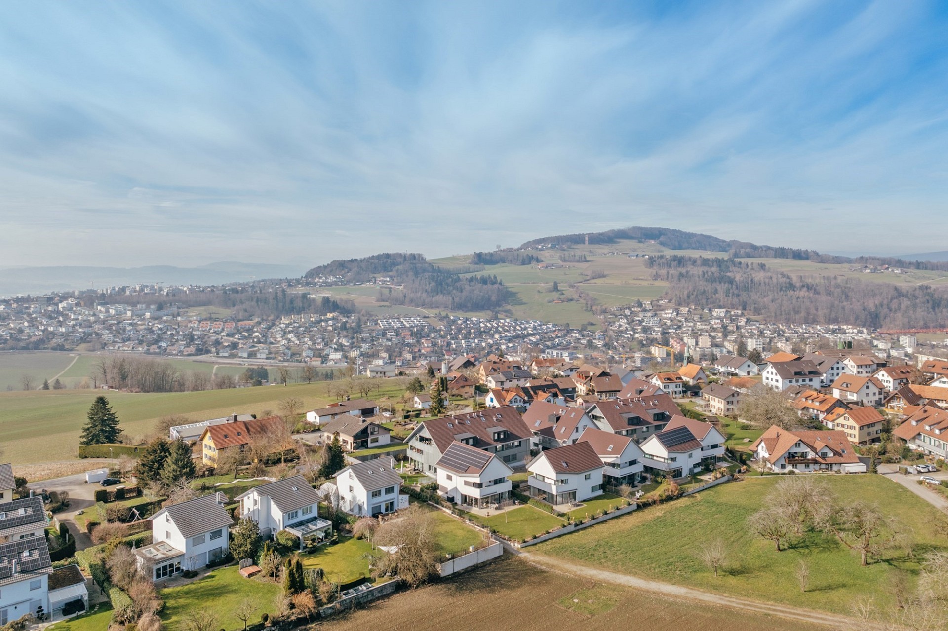 Luftaufnahme einer Wohnsiedlung mit Berg- und Landschaftsblick