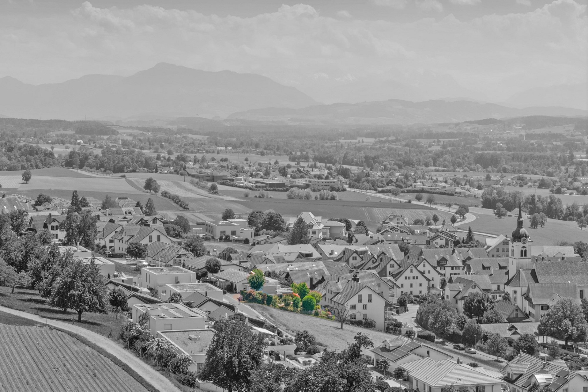 Panoramablick über ein Dorf im Tal mit Bergen im Hintergrund