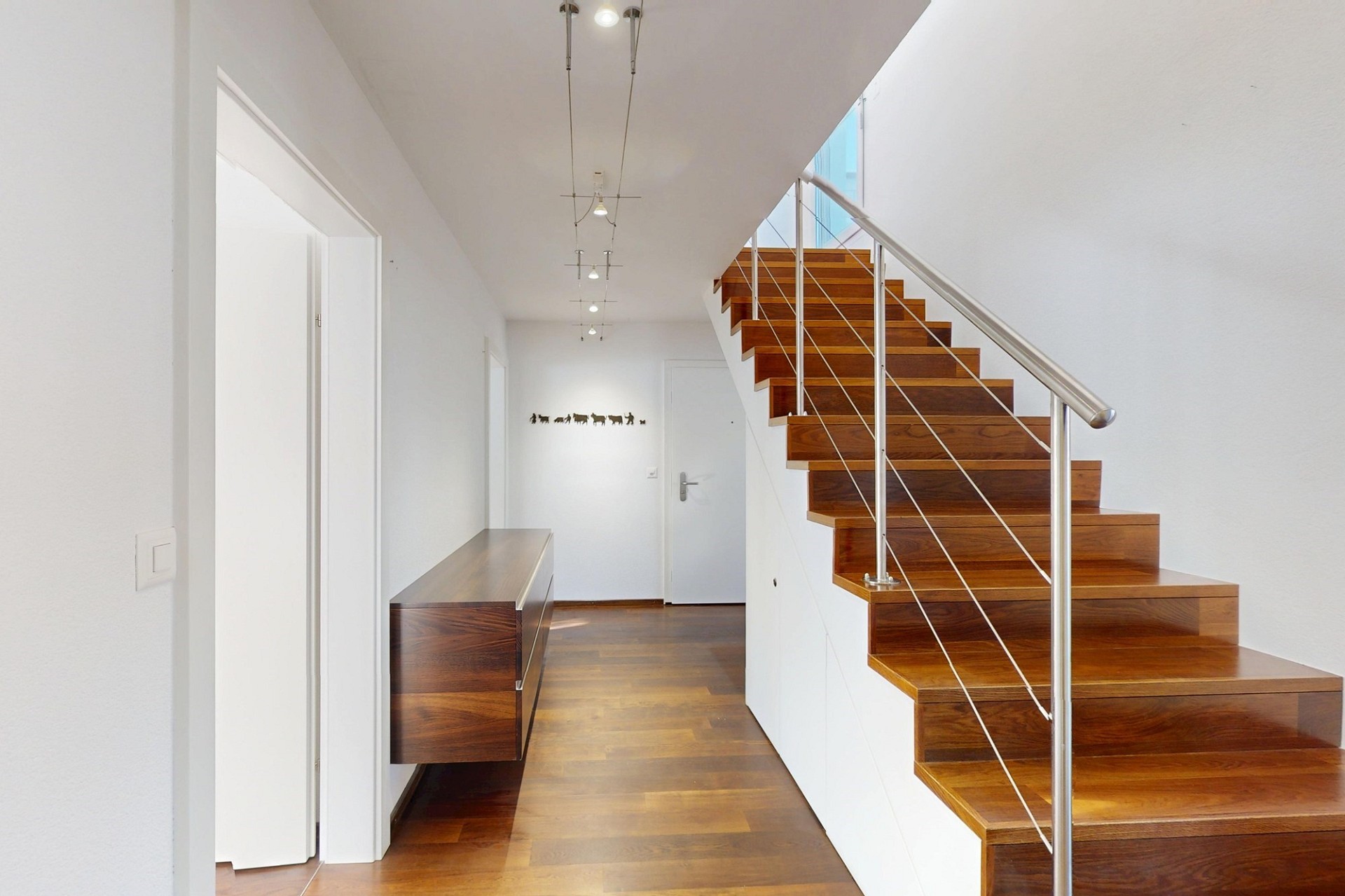 Moderner Eingangsbereich mit Holztreppe