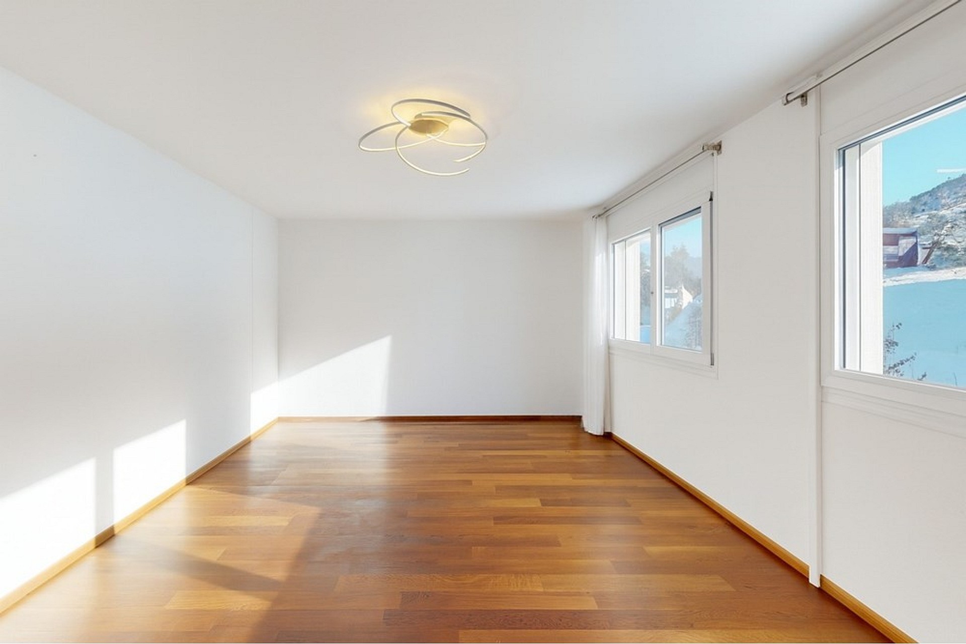 Helles, leeres Zimmer mit Holzfußboden