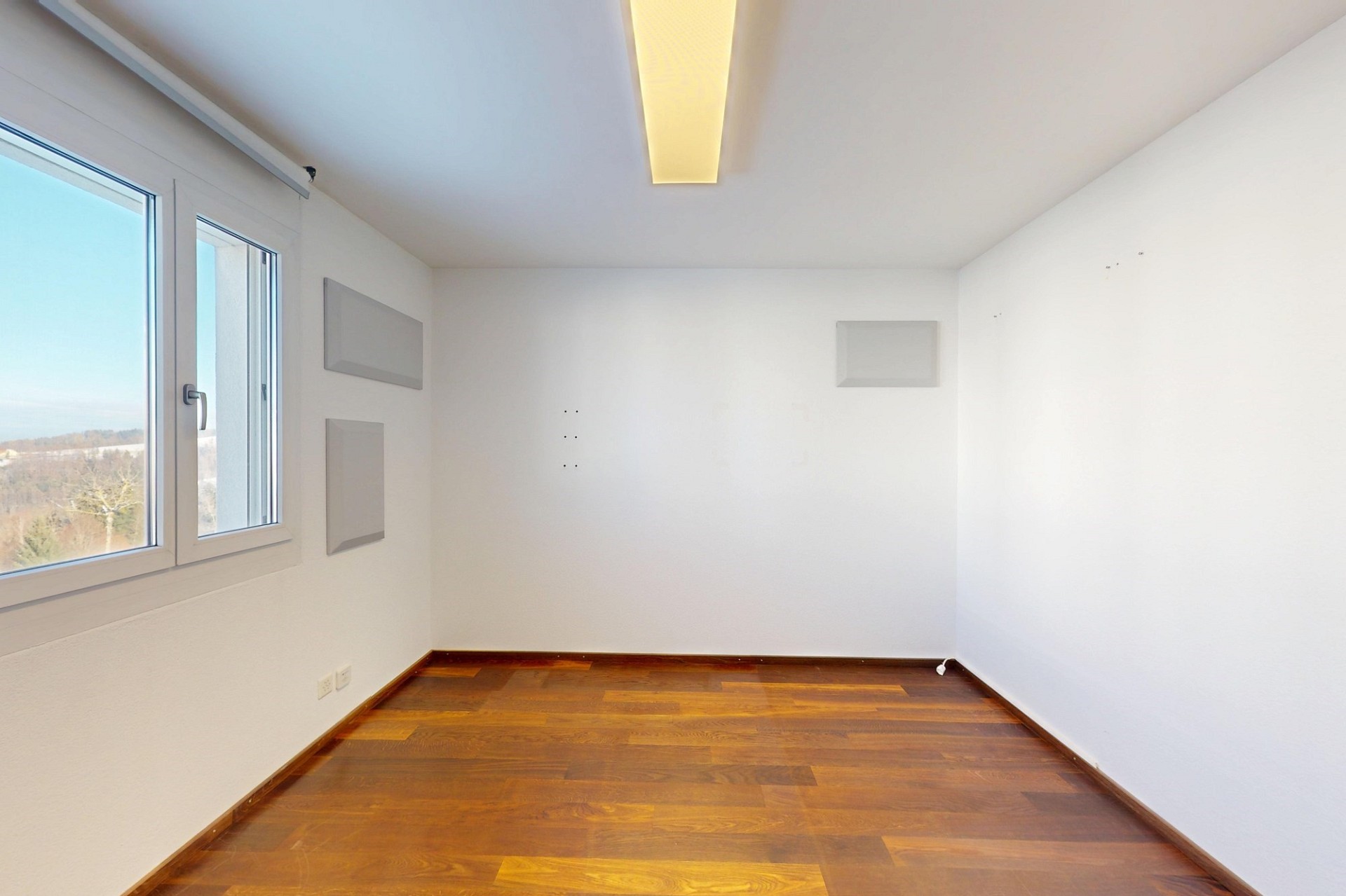 Leerer heller Raum mit Holzfußboden und Fensterblick