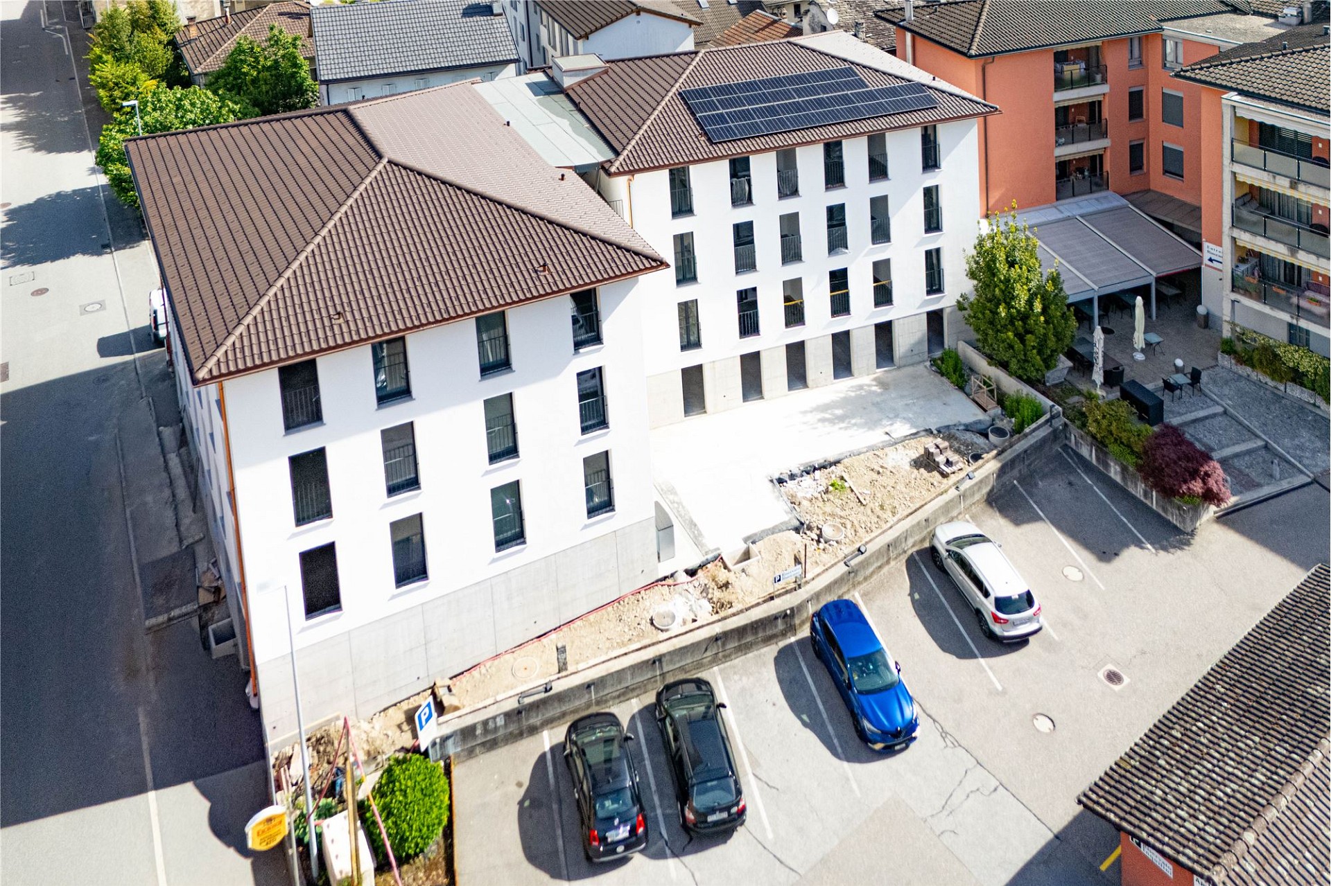 Luftaufnahme eines Wohn- und Apartmentkomplexes mit Parkplatz