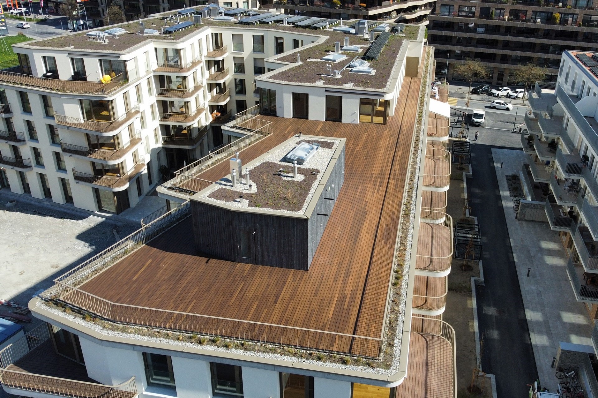 Drohnenaufnahme eines modernen Wohnkomplexes mit begrünten Flachdächern und großen Dachterrassen