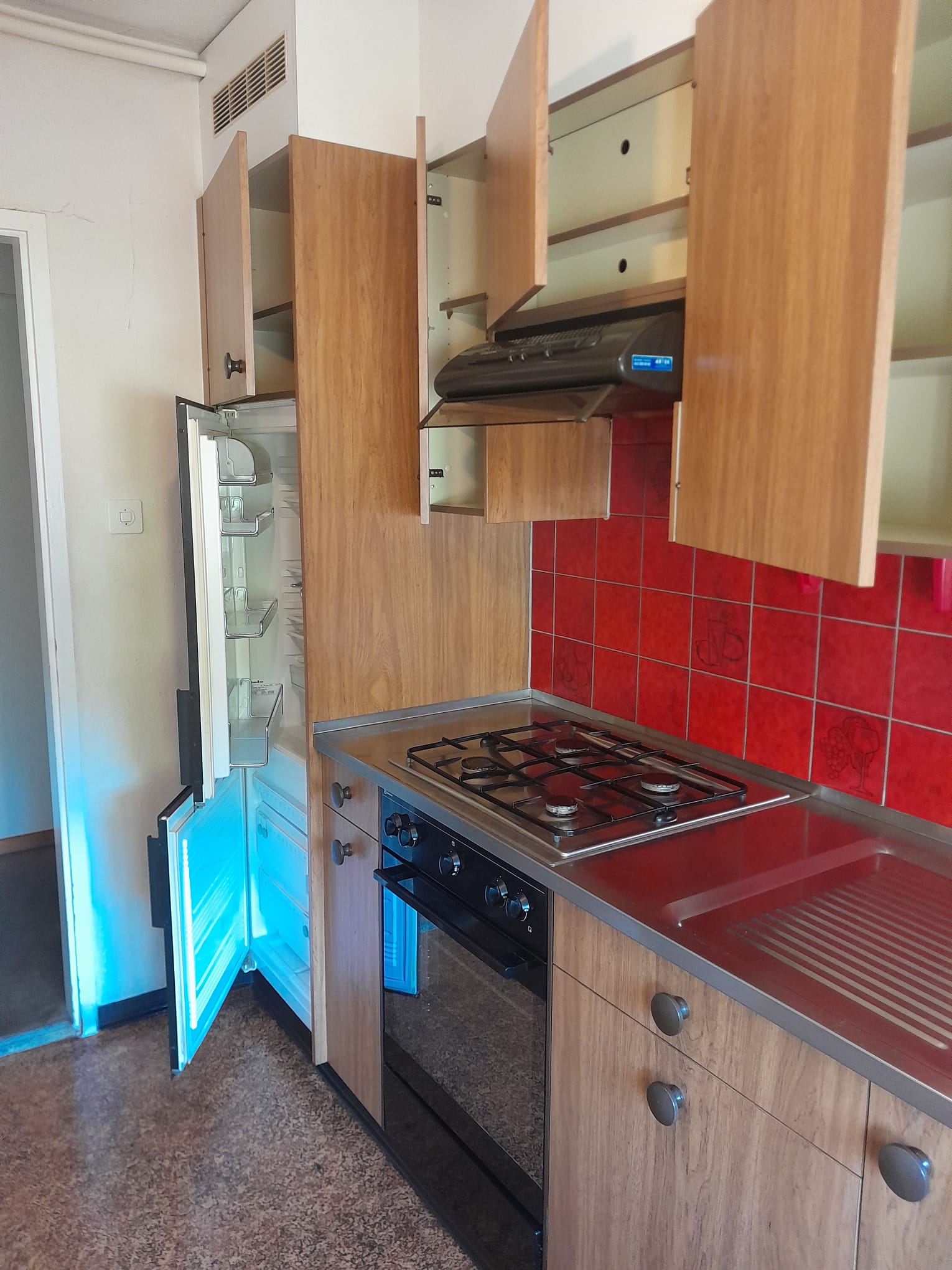 Kompakte Küche mit geöffnetem Kühlschrank