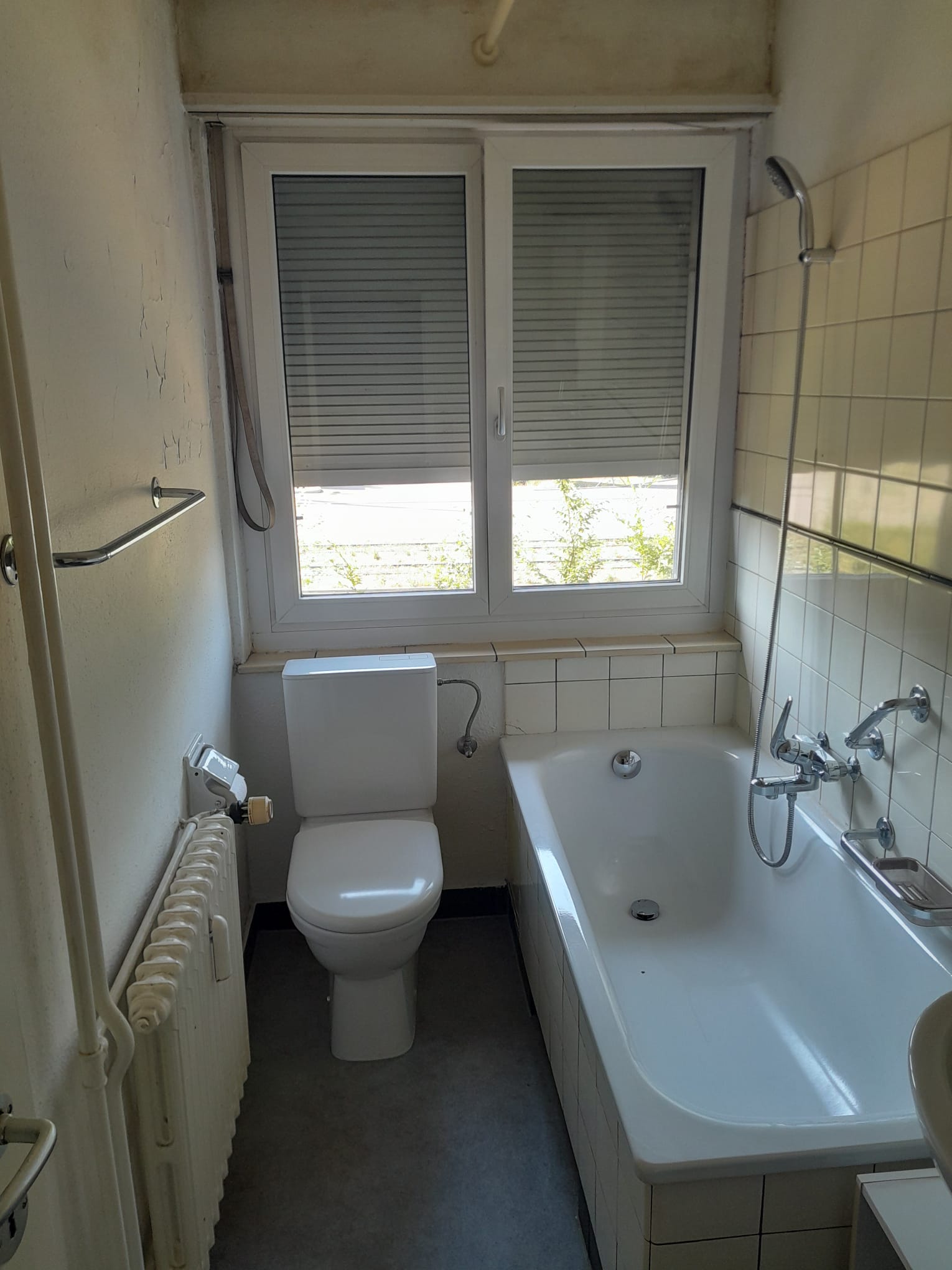 Kleines Badezimmer mit Badewanne und WC