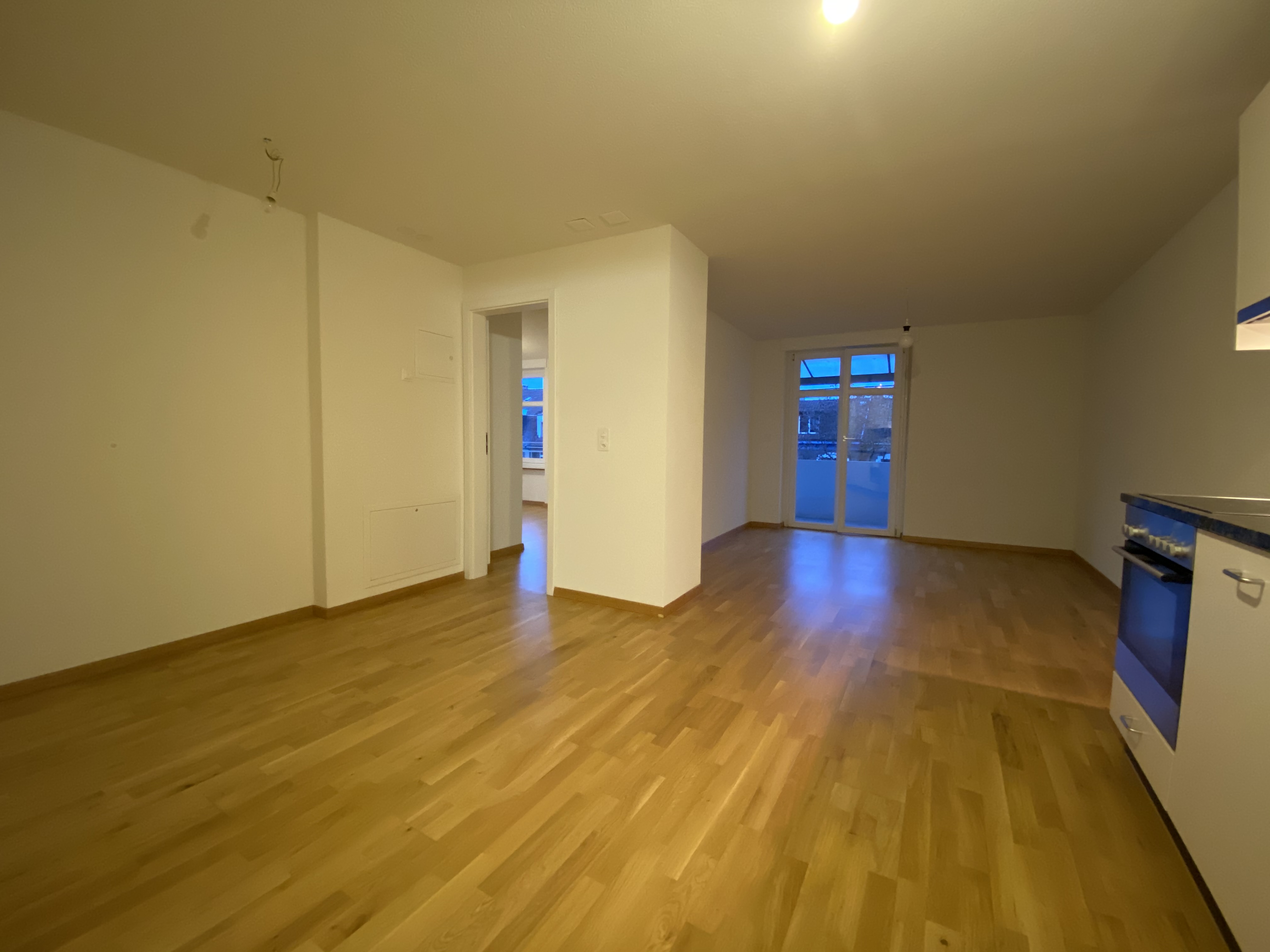 Leerer Wohnbereich mit Küchenanschluss