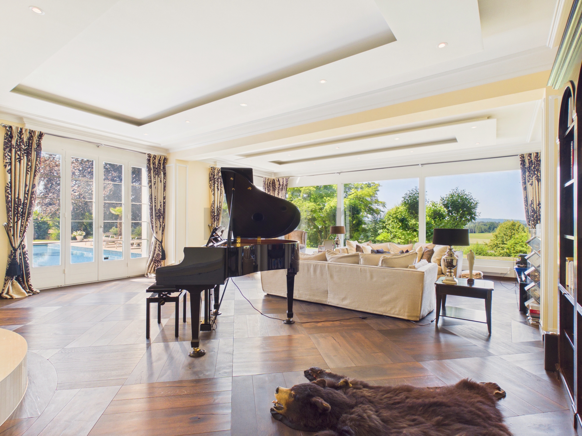 Luxuriöses Wohnzimmer mit Flügel und Panoramafenstern