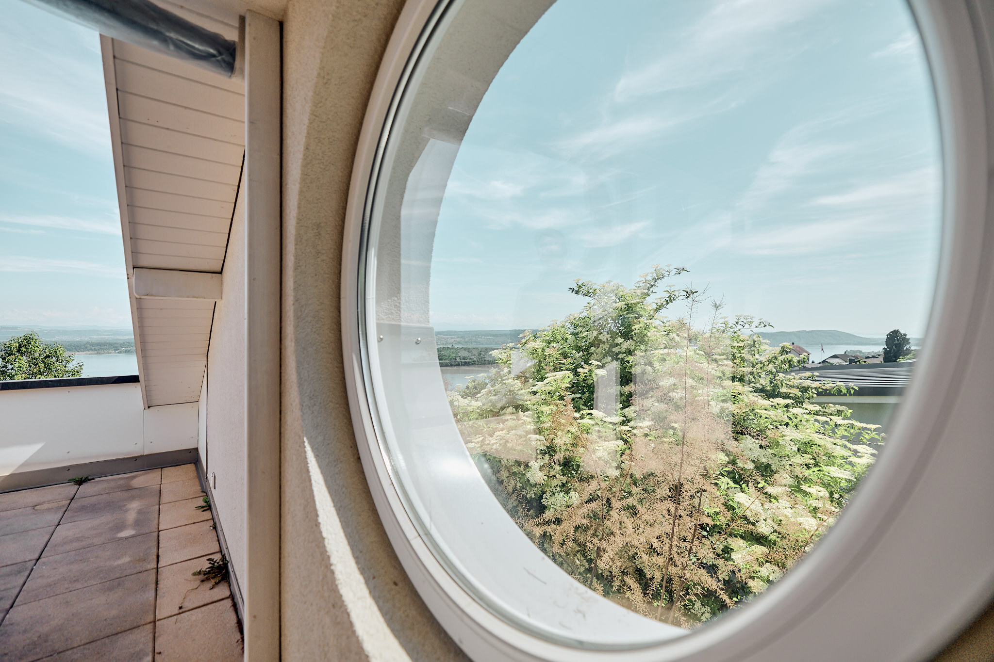 Balkon mit Rundfenster und Aussicht