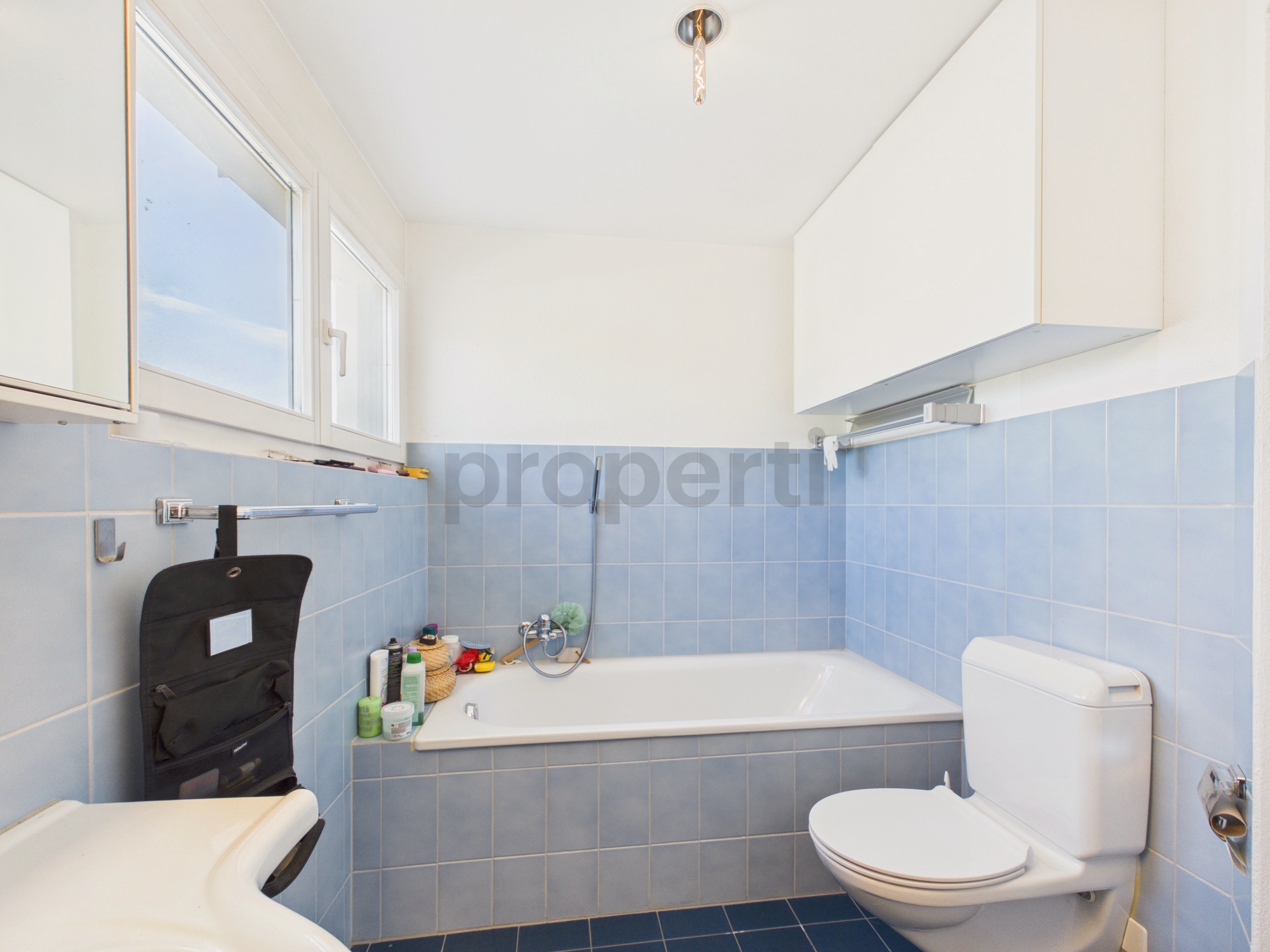 Kleines helles Badezimmer mit Badewanne und WC