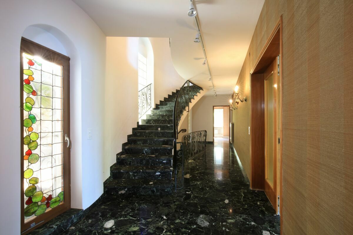 Eleganter Flur mit Treppe und Buntglas-Elementen