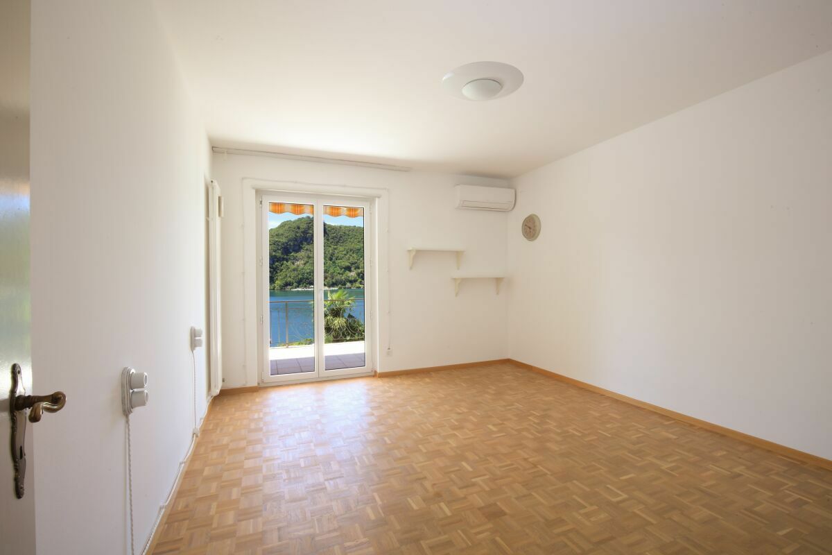 Leeres Zimmer mit Balkonblick auf Wasser und Hügel