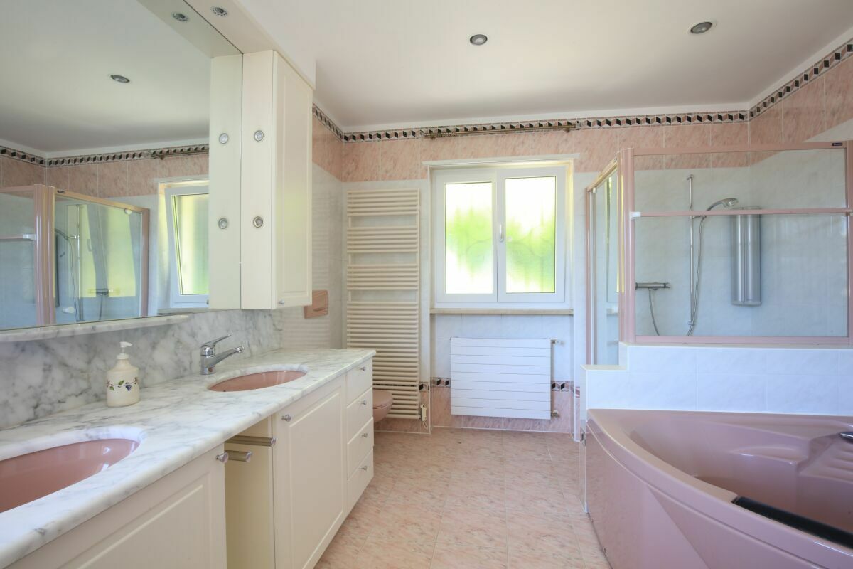 Geräumiges Badezimmer mit Doppelwaschtisch und Eckbadewanne