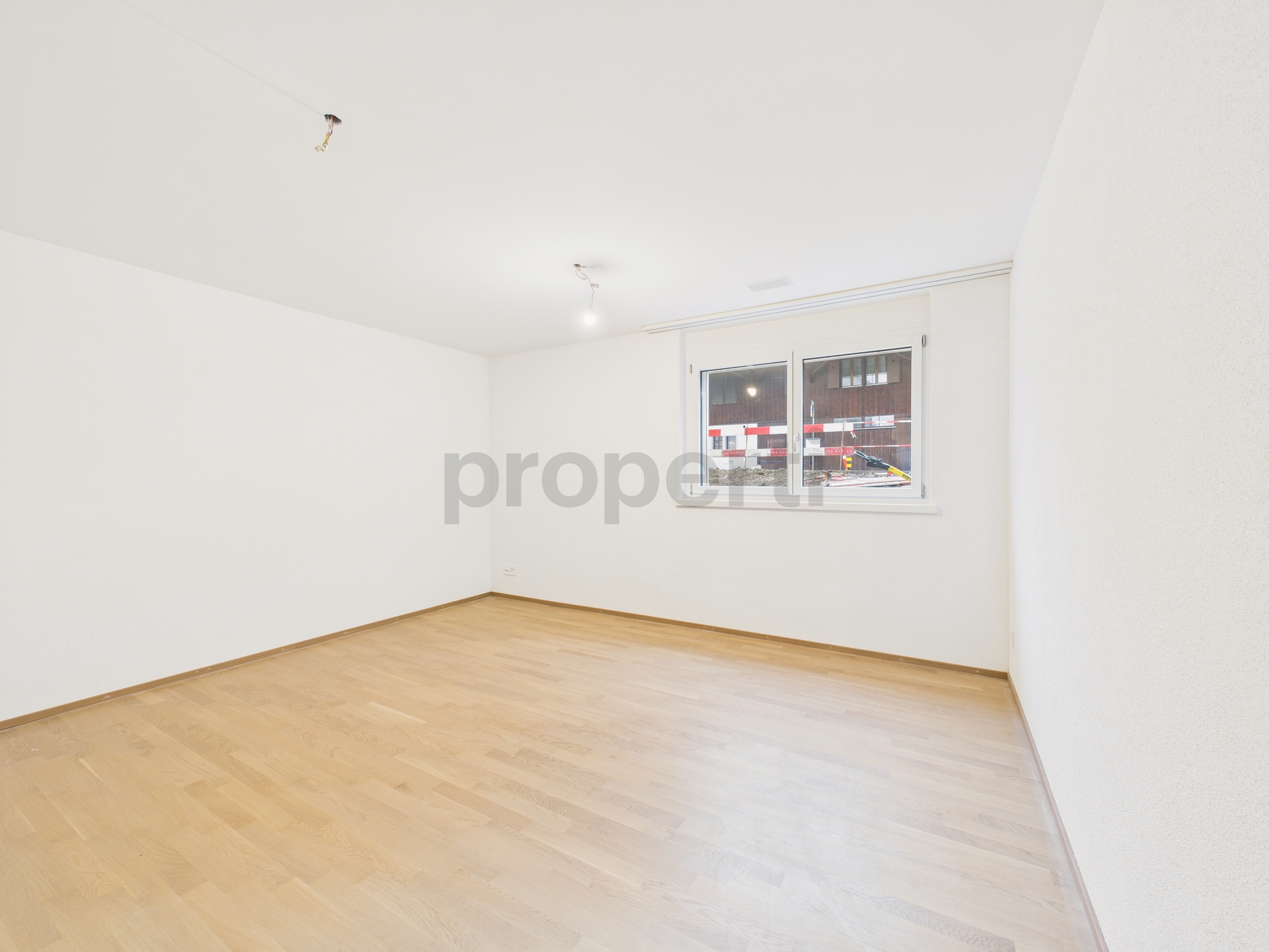 Leerer, heller Raum mit Parkettboden