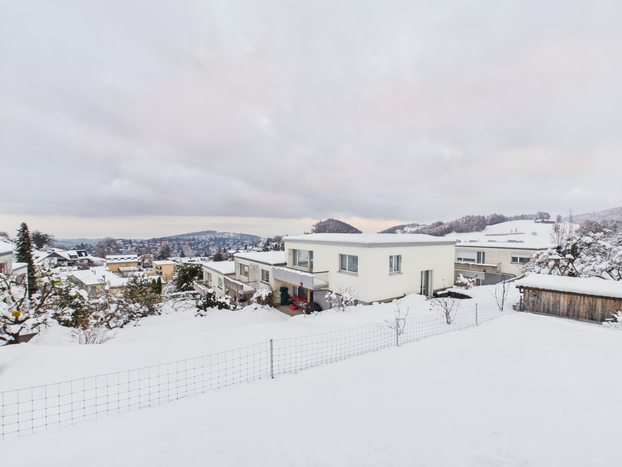 Verschneite Wohngegend mit Blick über ein modernes Haus
