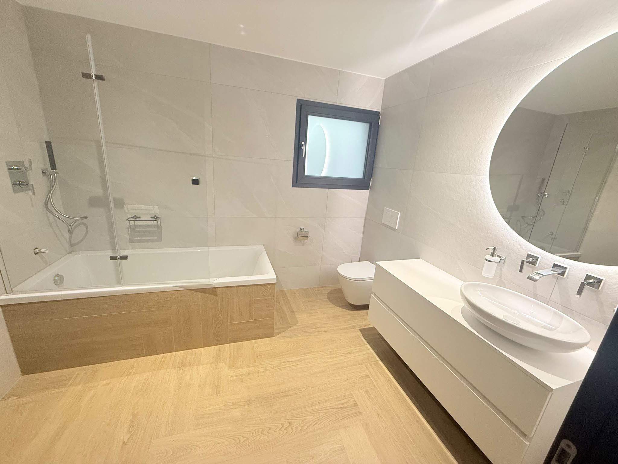 Modernes Badezimmer mit Wanne, Waschtisch und WC