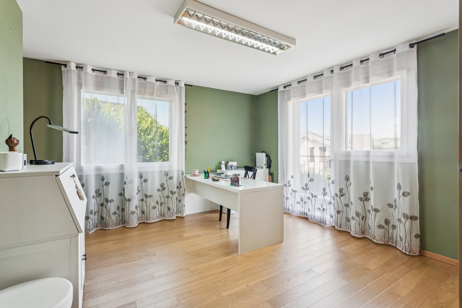 Helles Arbeitszimmer mit grün gestrichenen Wänden