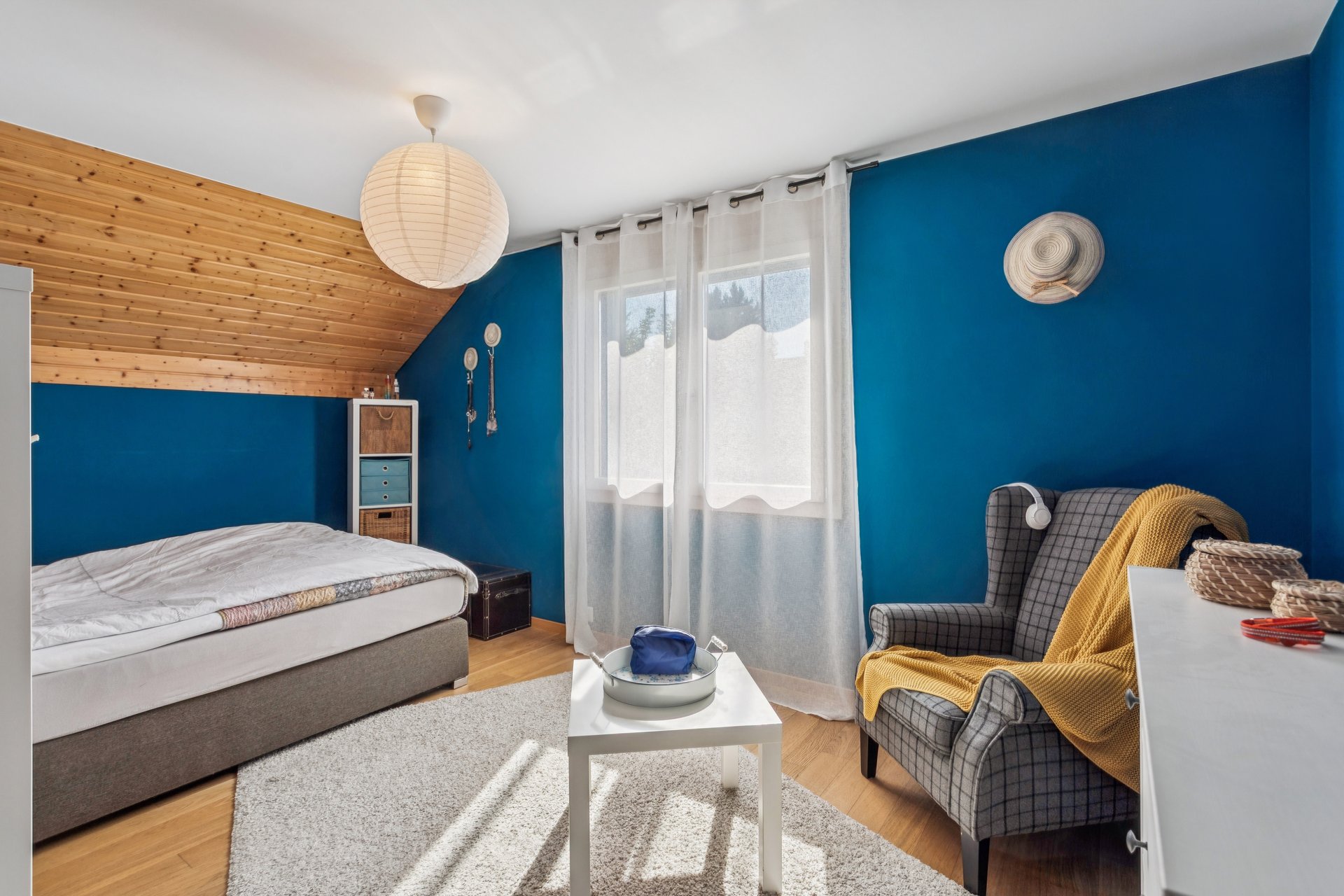 Gemütliches Schlafzimmer mit blauen Wänden und Holzdecke
