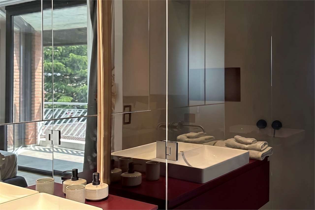 Modernes Badezimmer mit Spiegelwand und Balkonblick