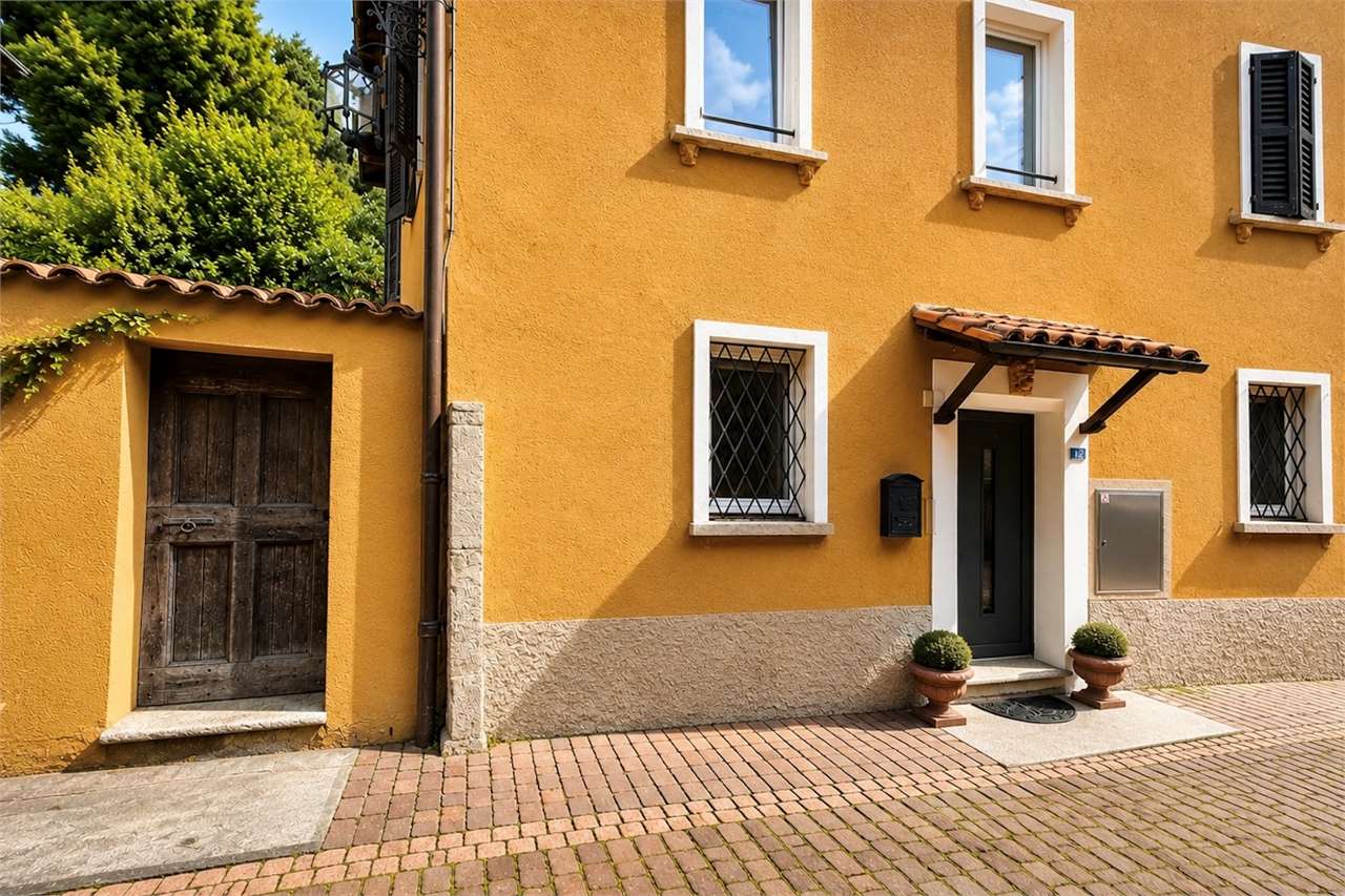 Farbige Hausfassade mit Eingang und Fensterläden