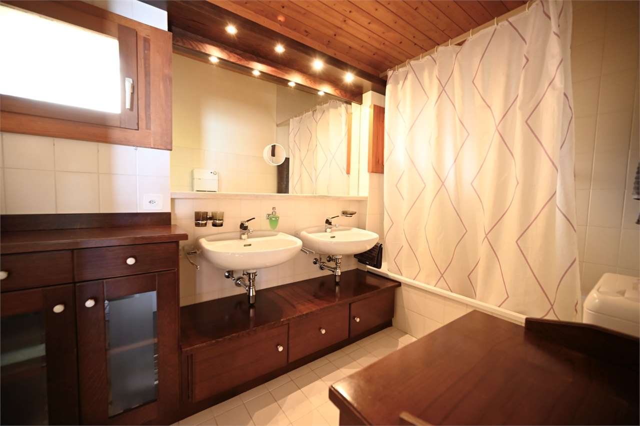 Badezimmer mit Doppelwaschbecken und Holzdecke