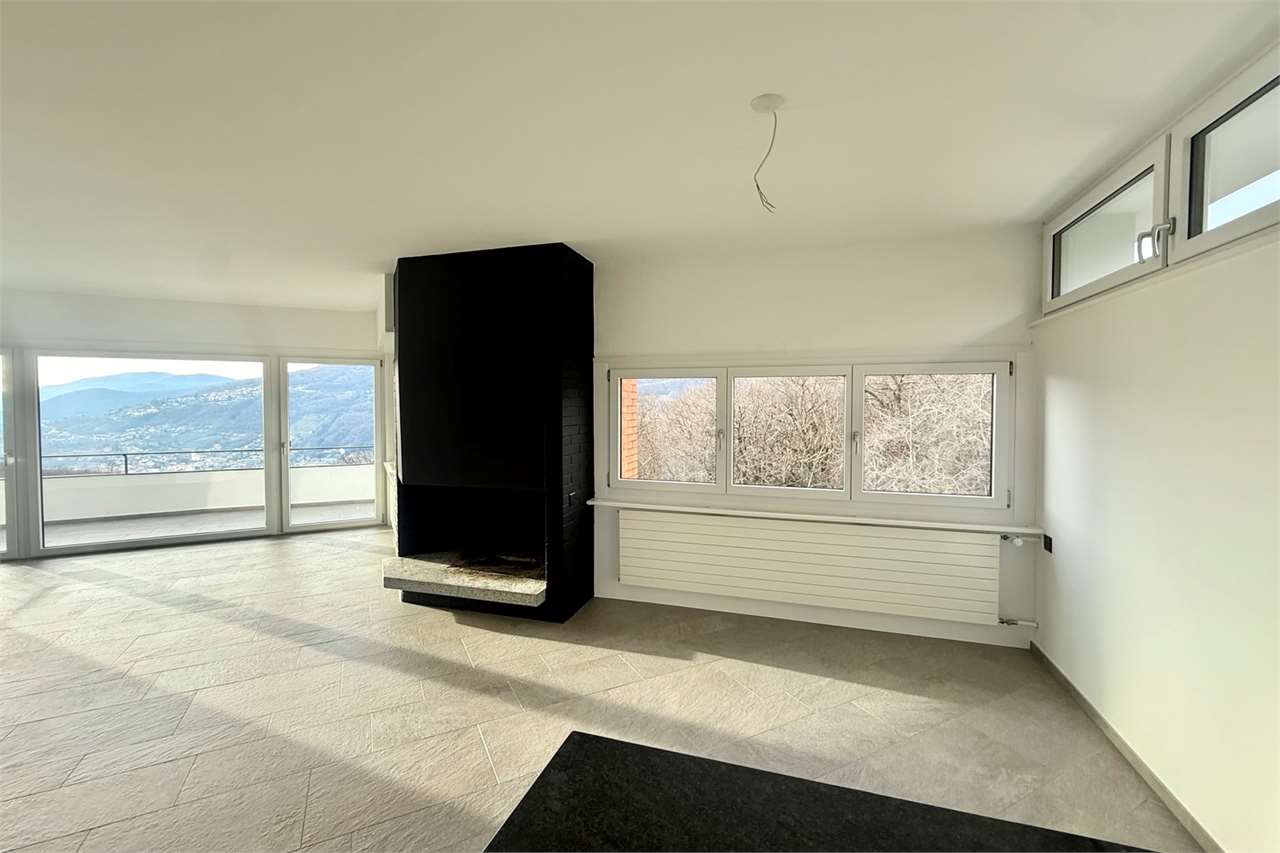 Heller Wohnraum mit Kamin und Bergblick