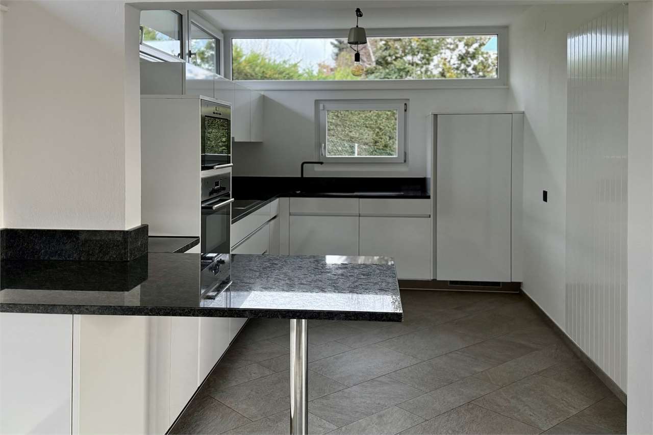 Moderne Küche mit Insel und großen Fensterbändern