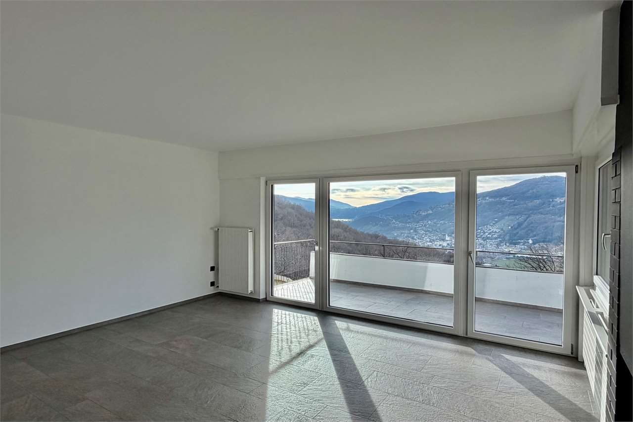 Leeres Wohnzimmer mit Panoramafenstern und Bergblick