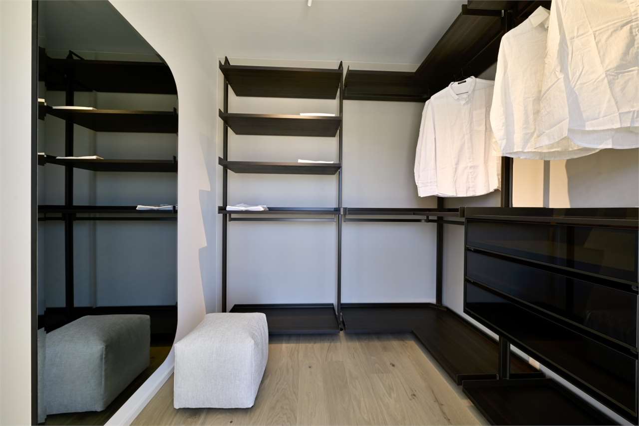 Begehbarer Kleiderschrank mit dunklen Regalsystemen