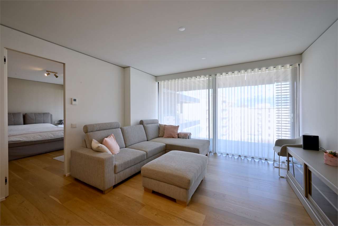 Helles Wohnzimmer mit Sofa und Balkonfenster