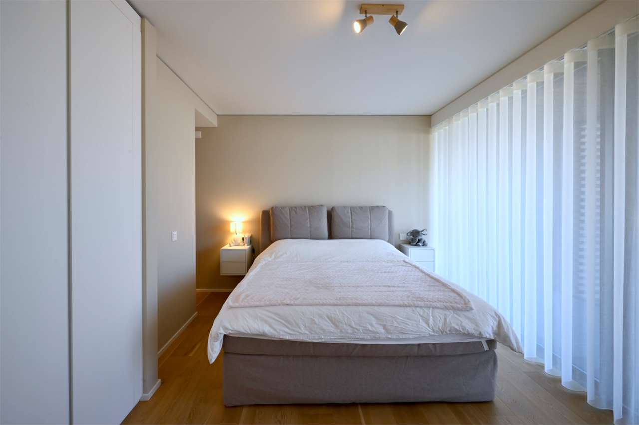 Helles Schlafzimmer mit großem Fensterfrontbereich