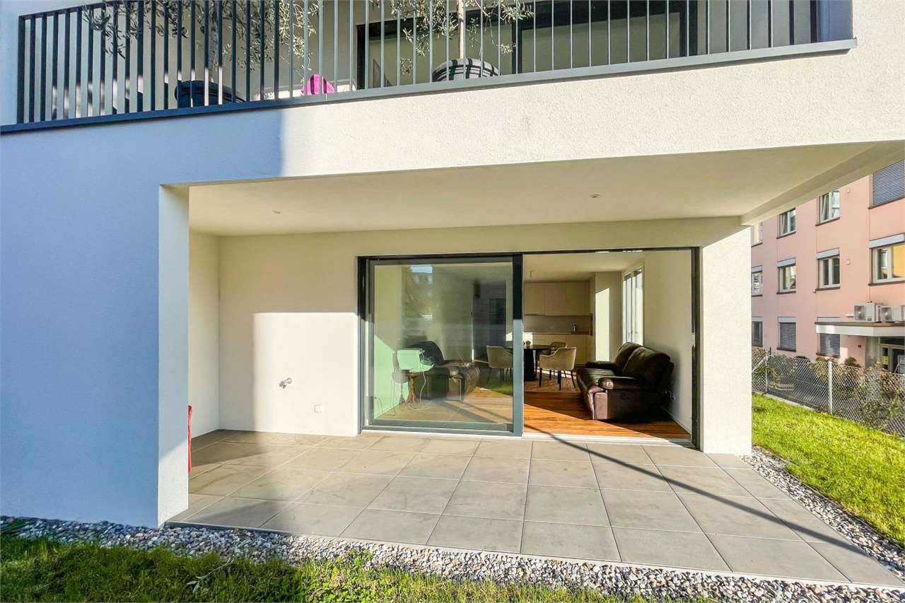 Außenbereich mit überdachter Terrasse und Blick ins Wohn-/Esszimmer