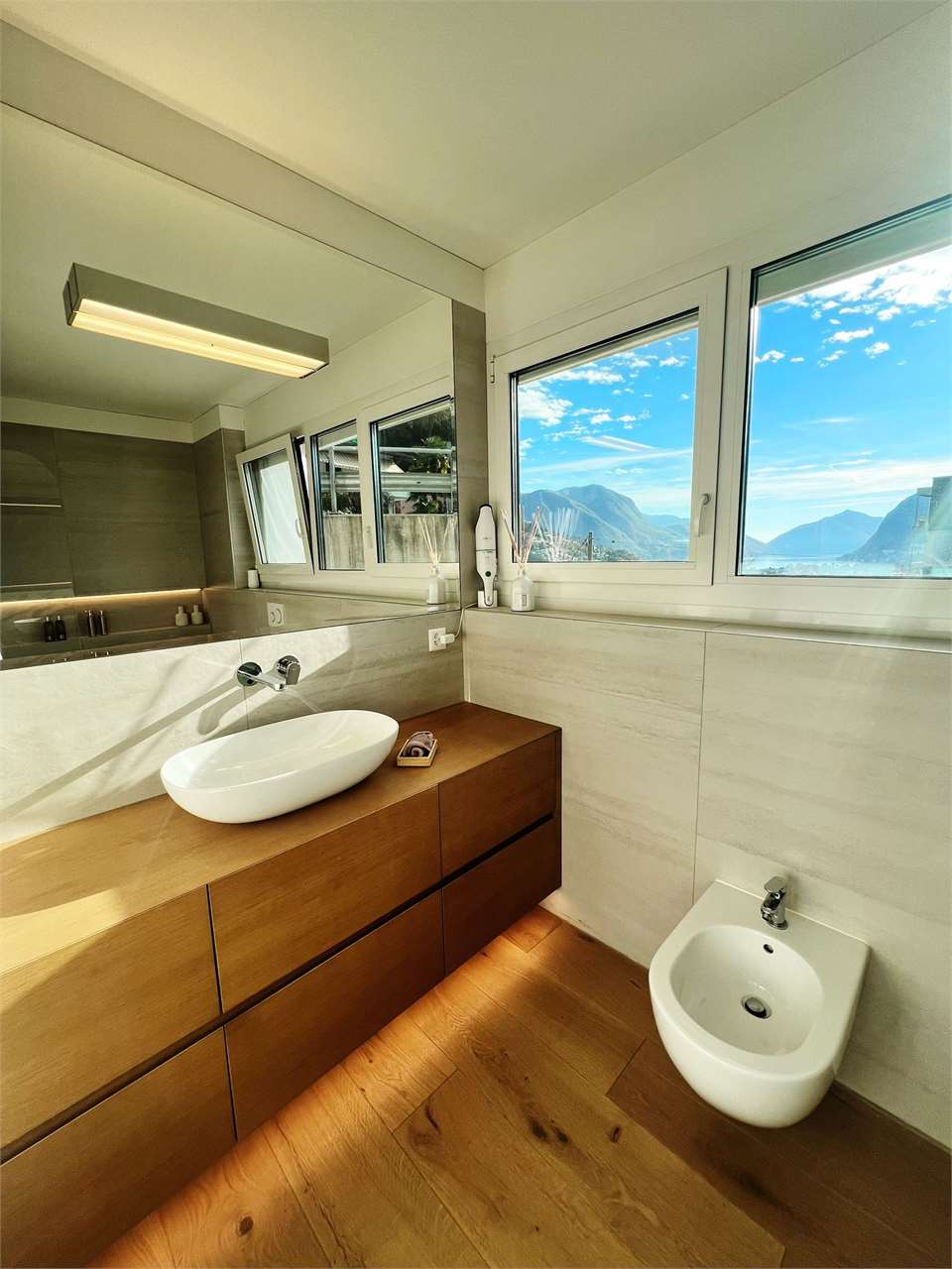 Helles Badezimmer mit Seeblick und Holzwaschtisch